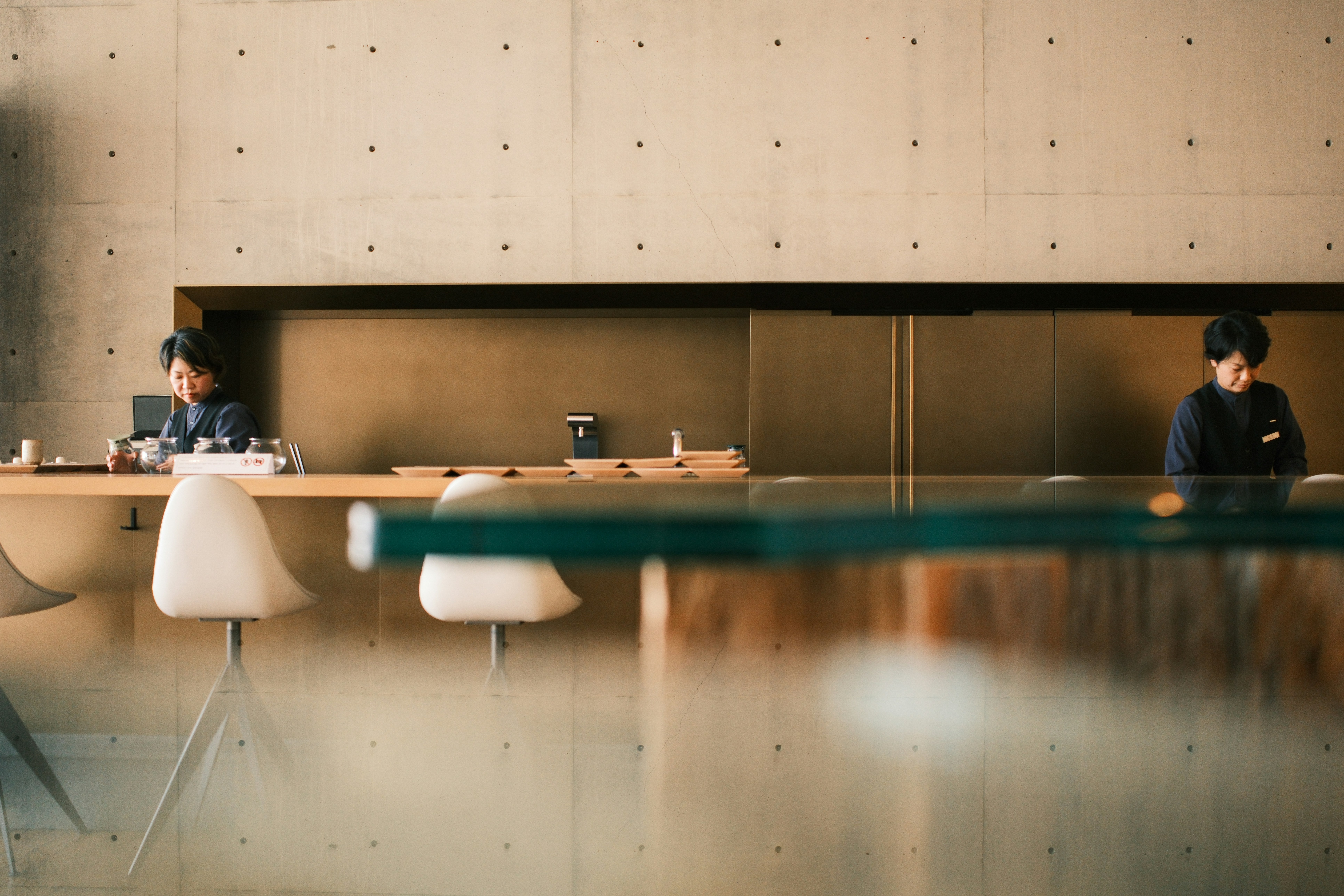 People sit at a minimalist cafe counter.