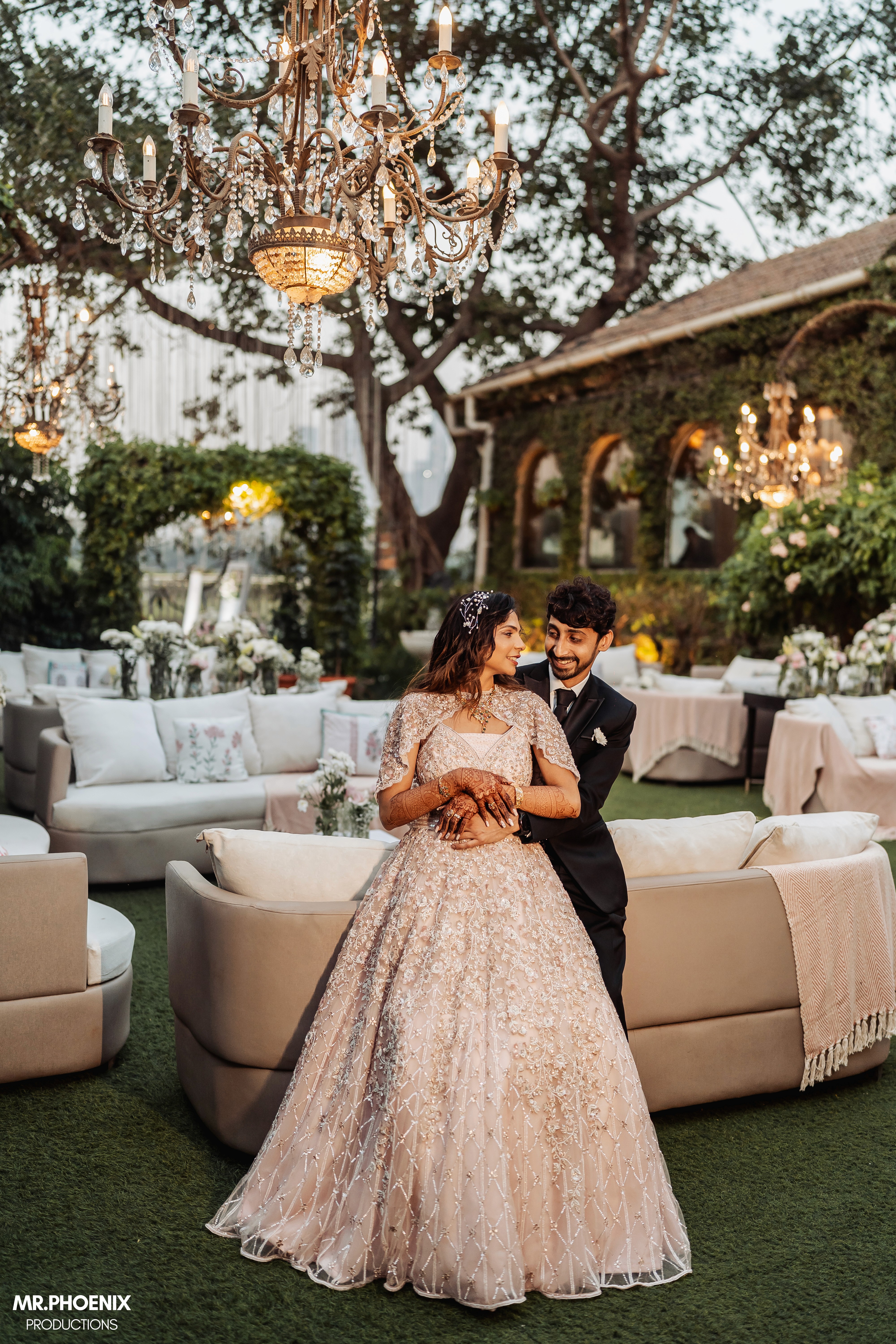 Dirt road flanked by vineyards and cypress trees, rolling hills, mist, and distant town in Tuscany.