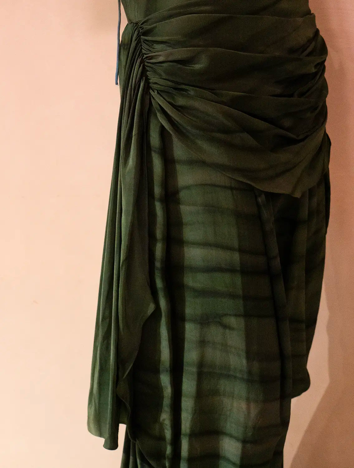 They feature asymmetrical tucks and fluid folds pinned at varying levels,