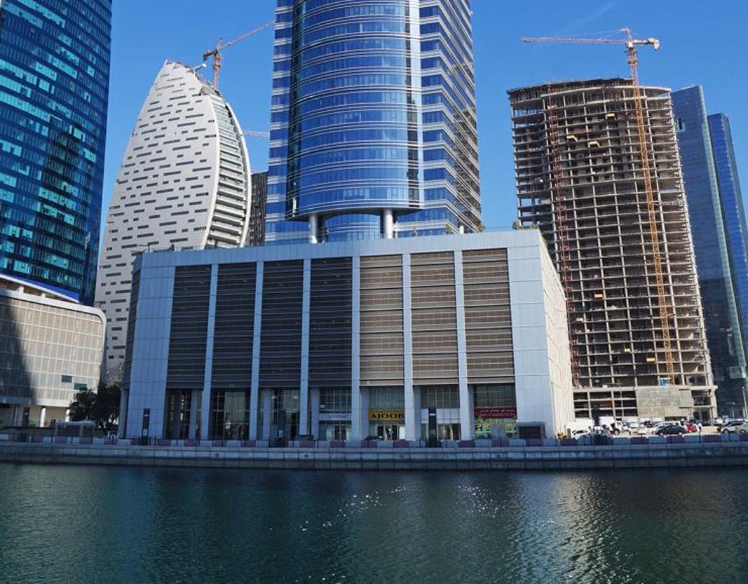 Skyline view of office towers and waterfront property listings in a prime business district.