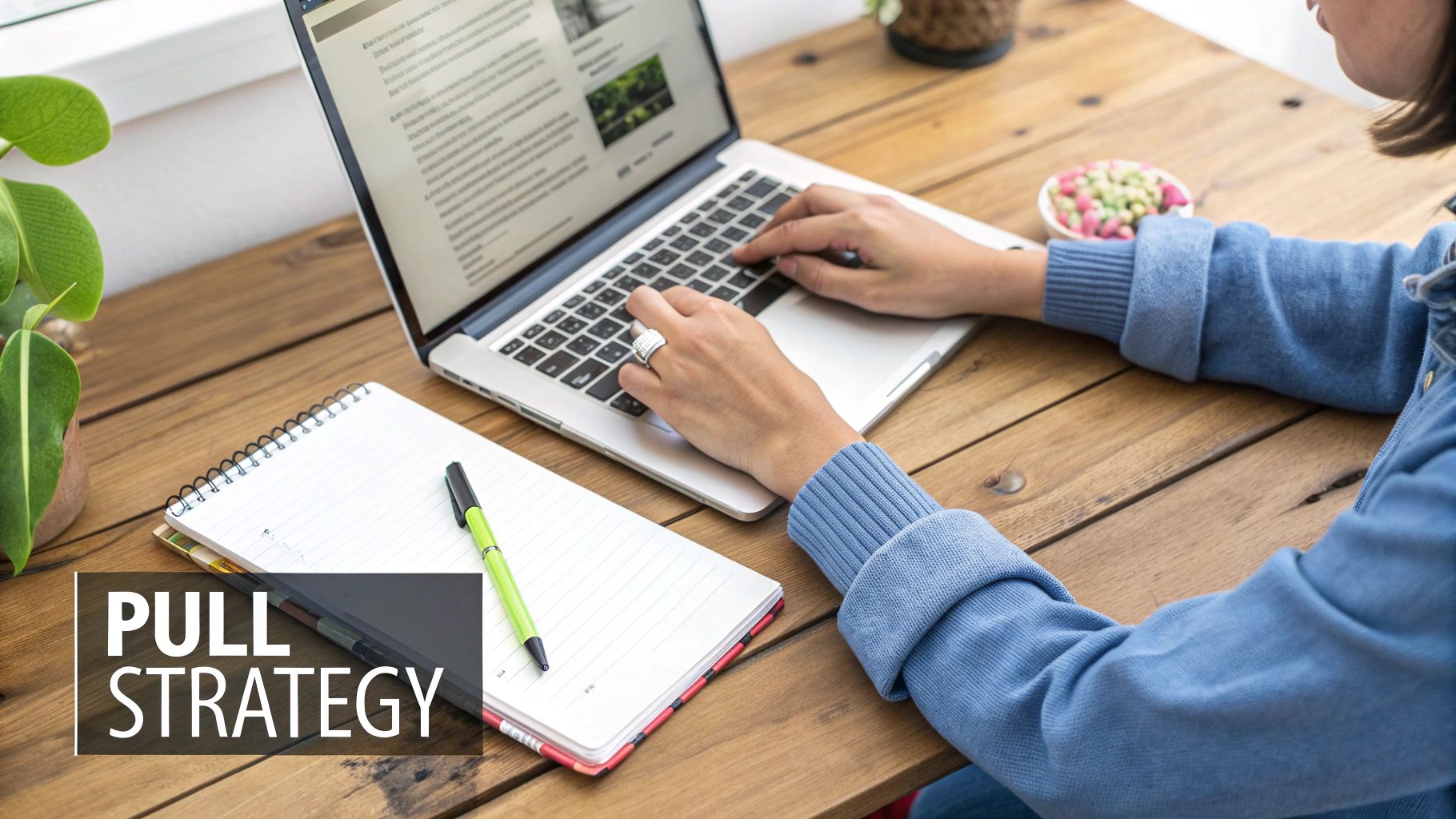 Persoon werkt aan een laptop op een houten bureau met notitieboek en pen, wat strategieplanning visualiseert.