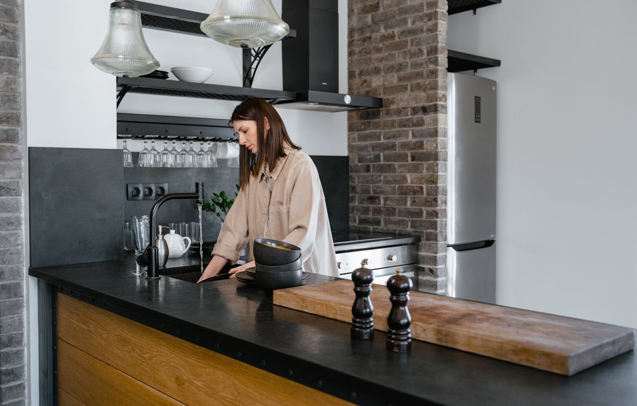 Woman cleaning dishes in kitchen