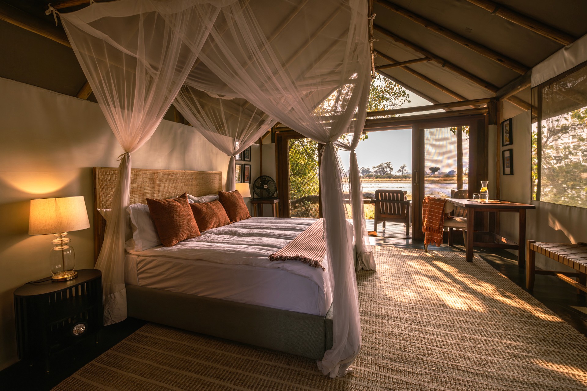 Kujwana Delta Ride, Okavango Delta, Botswana. Lyxigt och rymligt boende på Kujwana Camp. Vackert bäddad dubbelsäng med myggnät runtomsig, mjuk matta på golvet, lampor som ger ett mysigt sken och öppna dörrar från rummet som har utsikt över Okavango Delta.