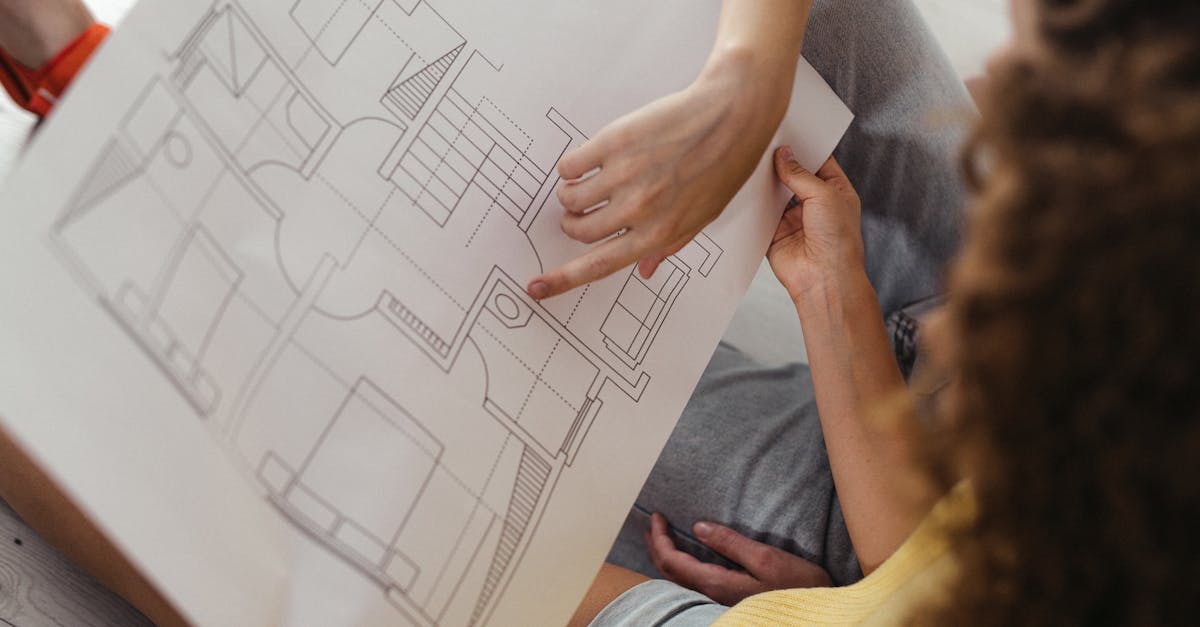 Two people reviewing and discussing a detailed architectural floor plan.