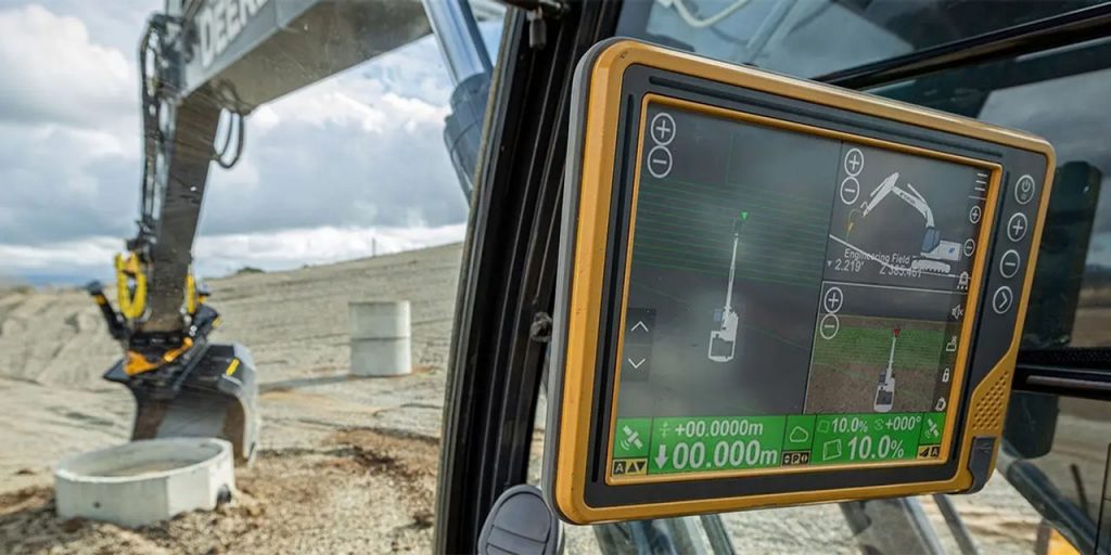 GPS machine control display inside an excavator cab showing cut and fill guidance on a grading site