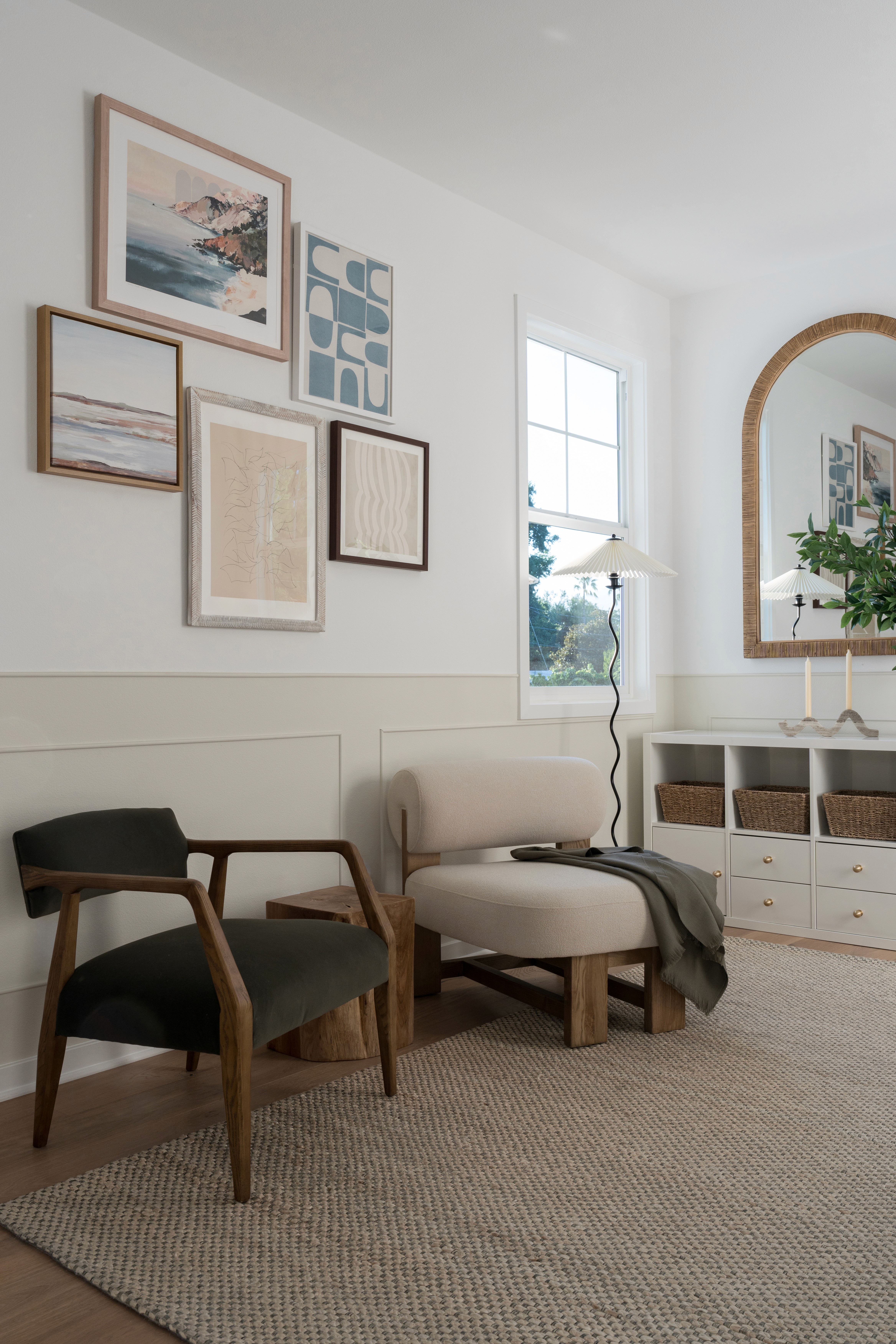 Open loft area with modern velvet armchairs, gallery wall, pleated floor lamp, and wood framed arched mirror by Jubilee Interiors in Arcadia, California