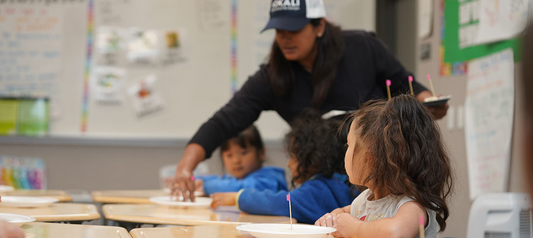 Young chefs practicing food preparation techniques in interactive culinary workshop
