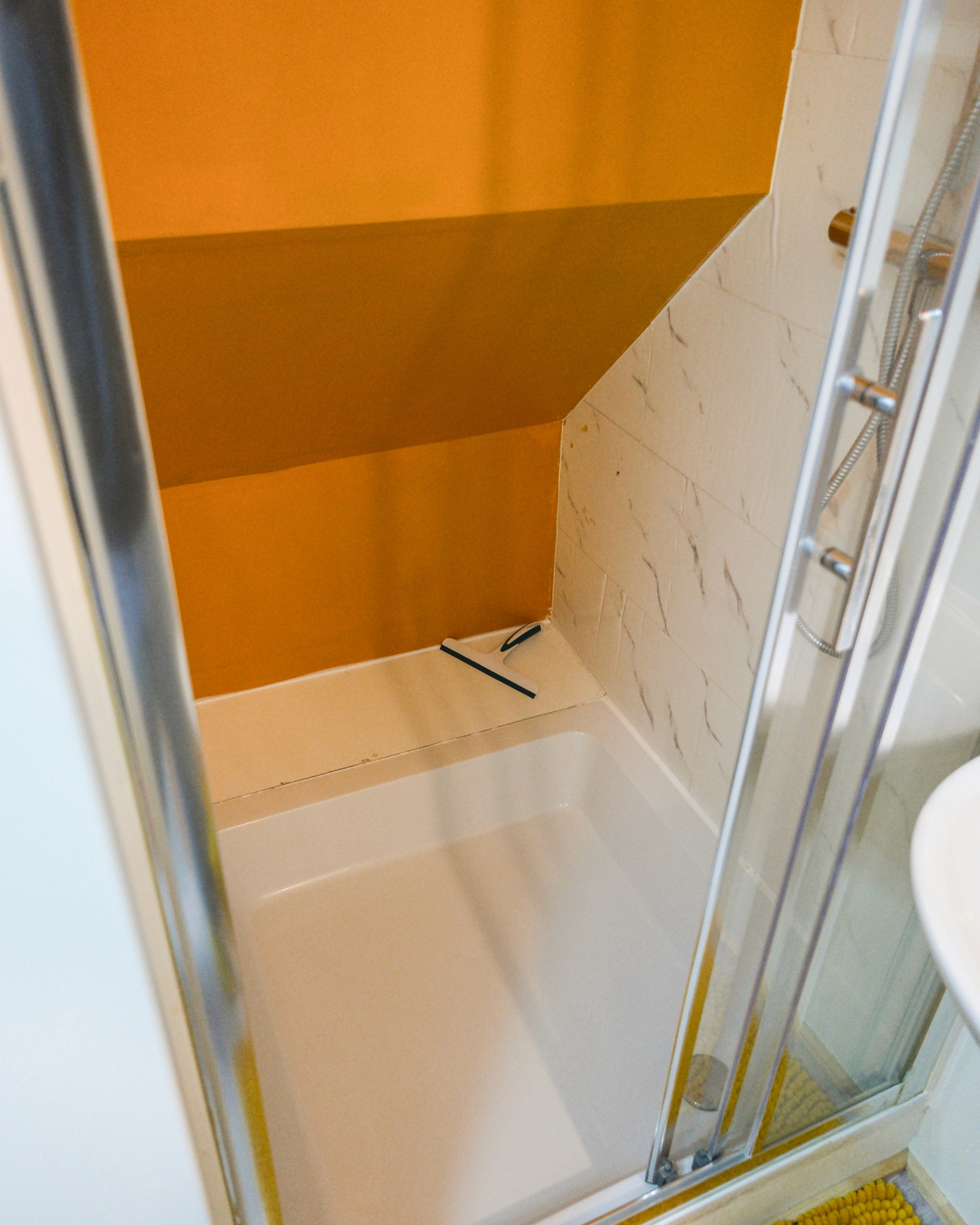 Grey marble bathroom with round mirror and floating sink
