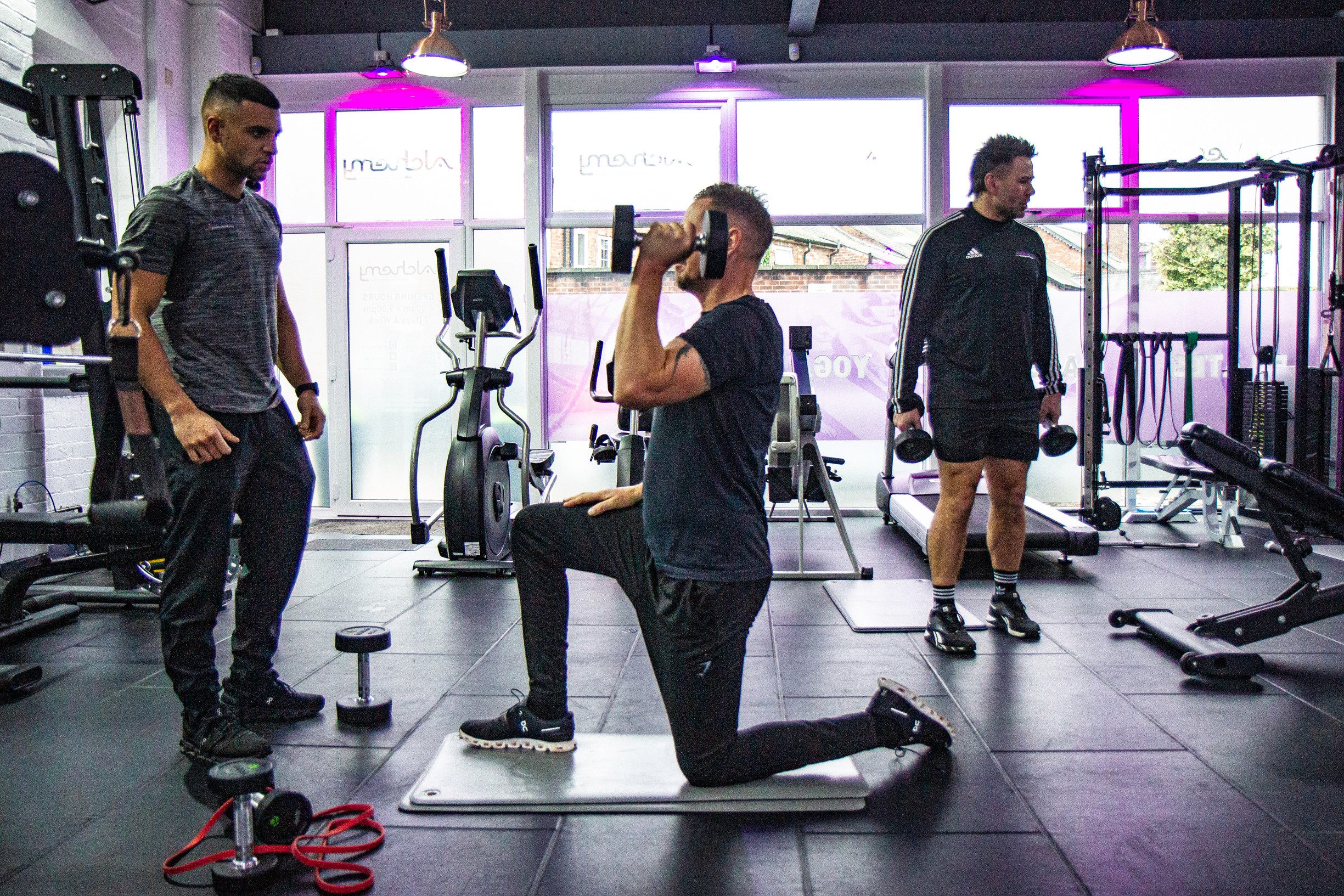 A man doing alternating military press in the gym to tone arms