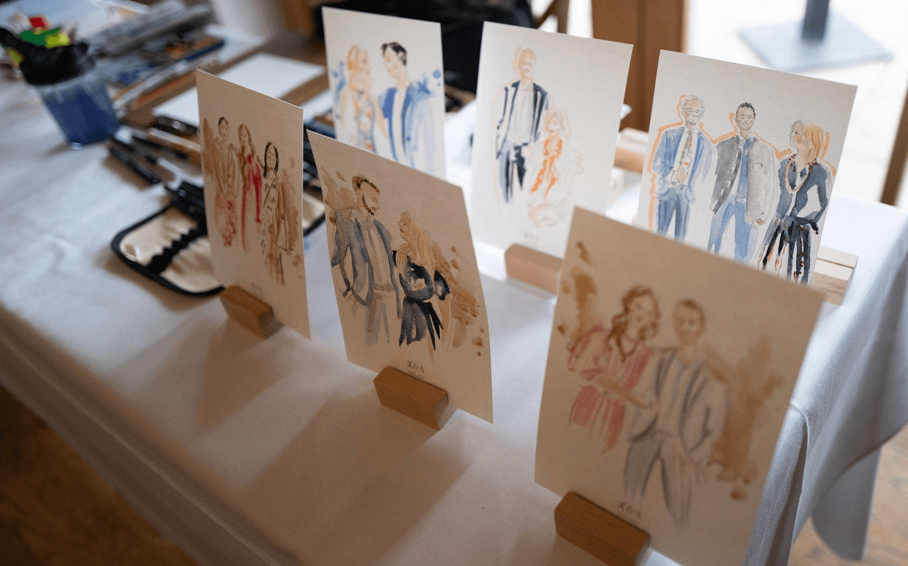 Eine Galerie aus Live-Skizzen auf einem Hochzeitstisch – edle Illustrationen als besonderes Highlight der Abendunterhaltung.