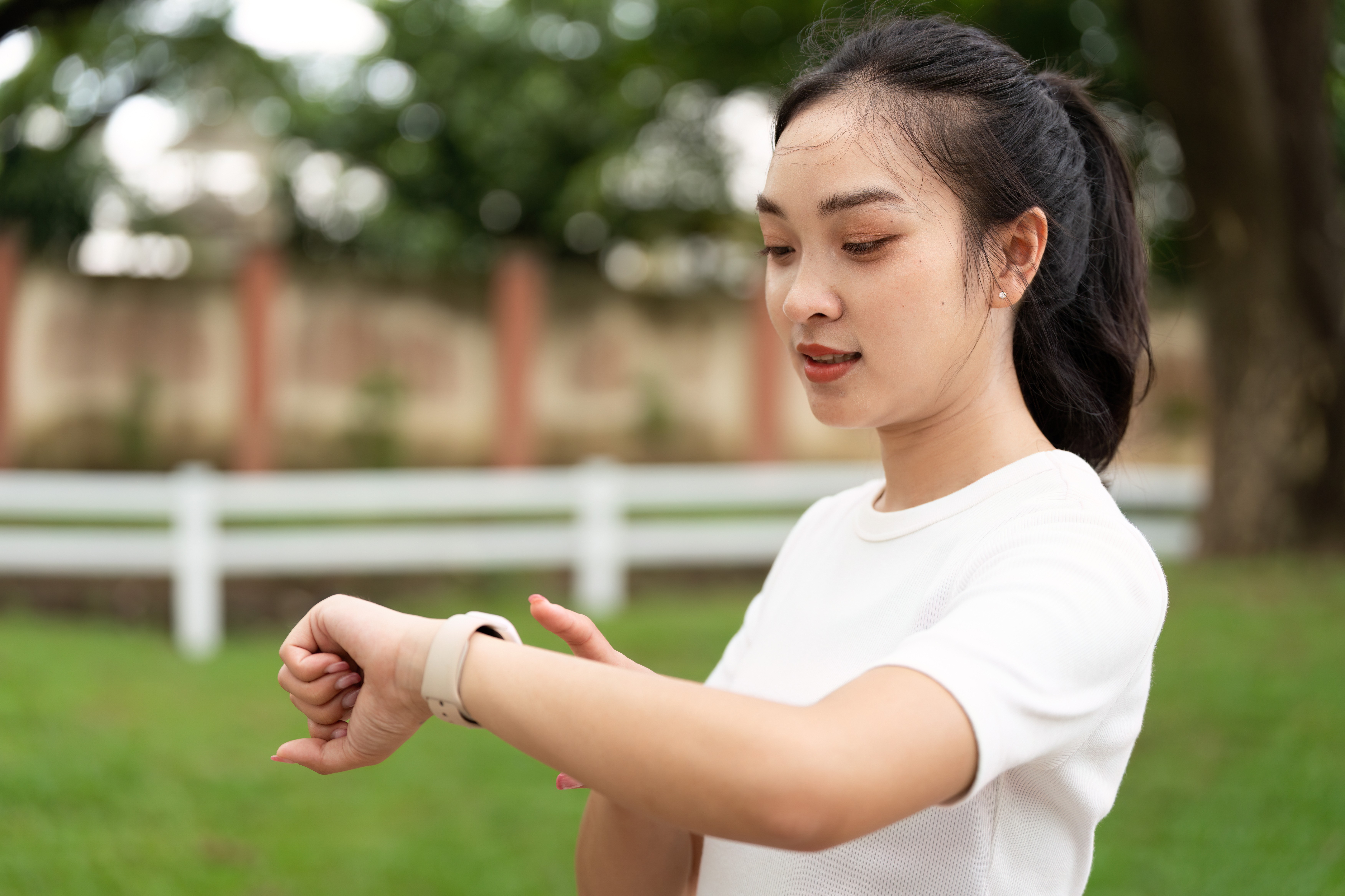 Woman in a park looking at her smart watch