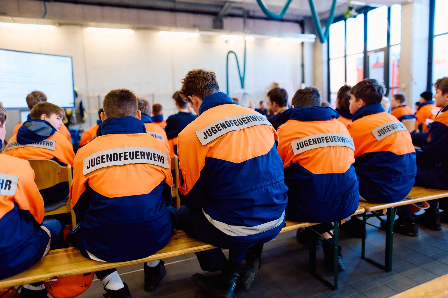 Feuerwehr-Mitarbeiter sitzen auf einer Bank