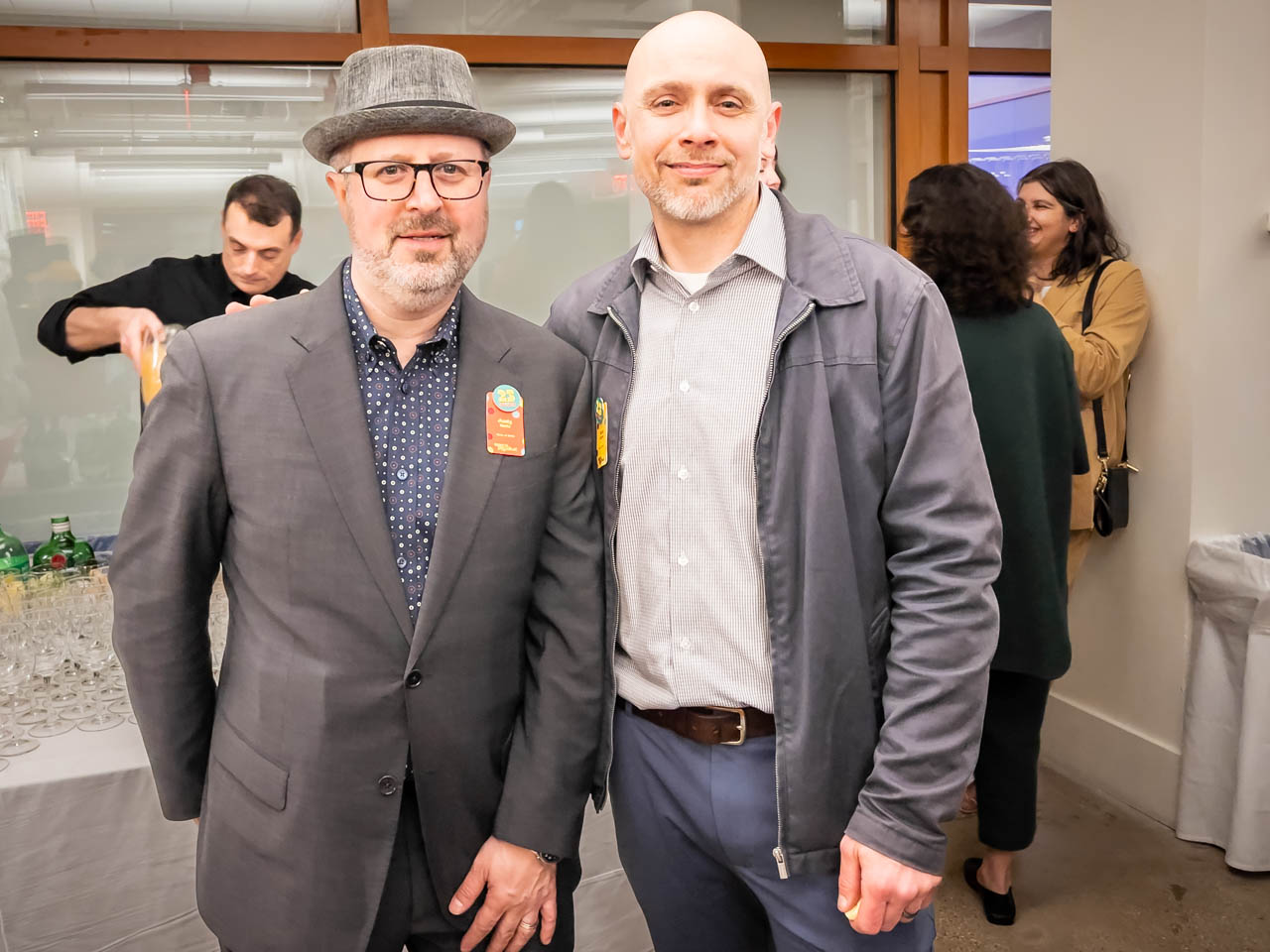 two people at a cocktail party looking at the camera