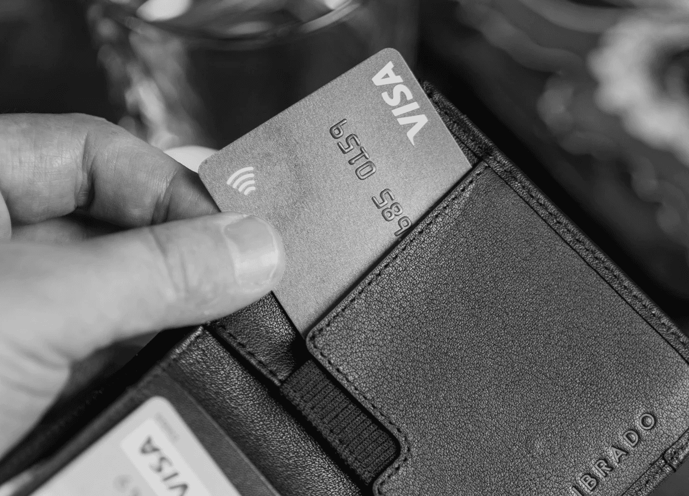 black leather bifold wallet on persons hand