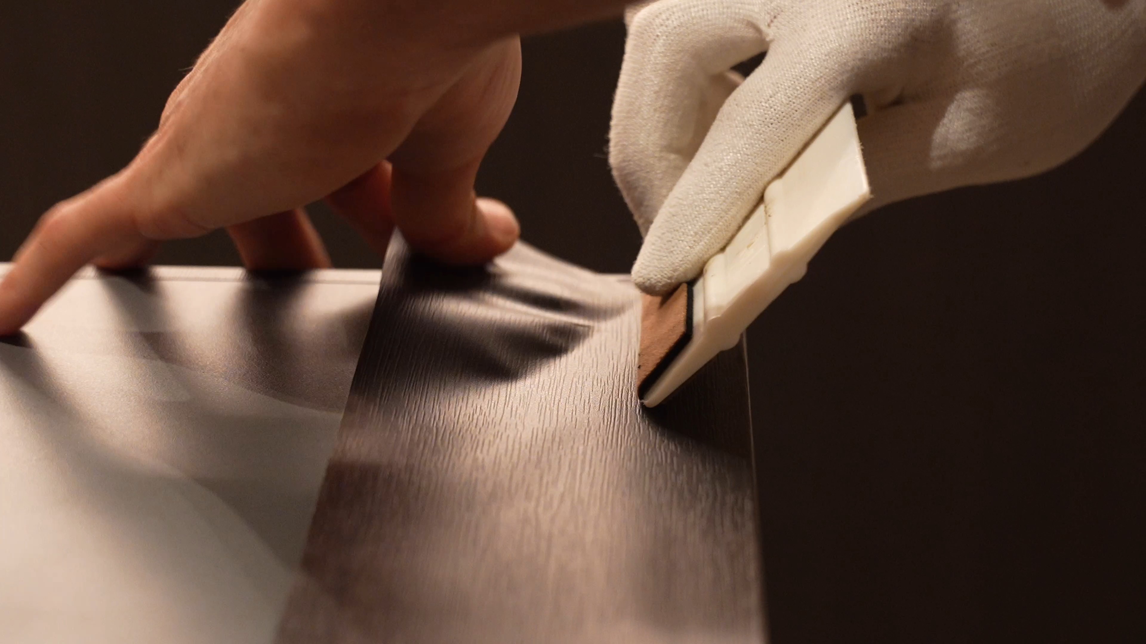 Minimalist facade with red window and striped awning on a white stucco wall under a clear blue sky.