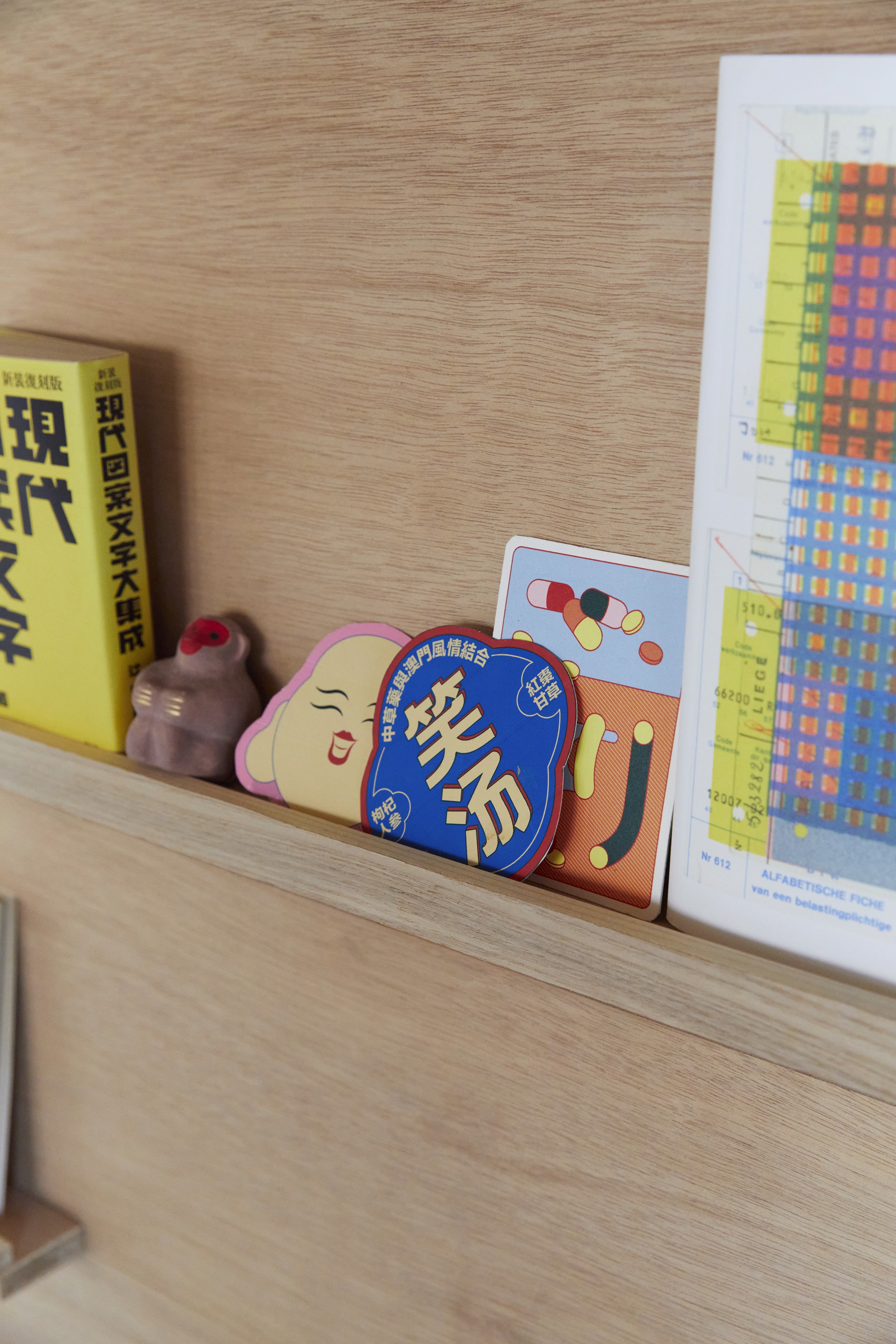 Close up of a shelf in Josephine Grenier’s studio showing graphic stickers and small items from her design projects.