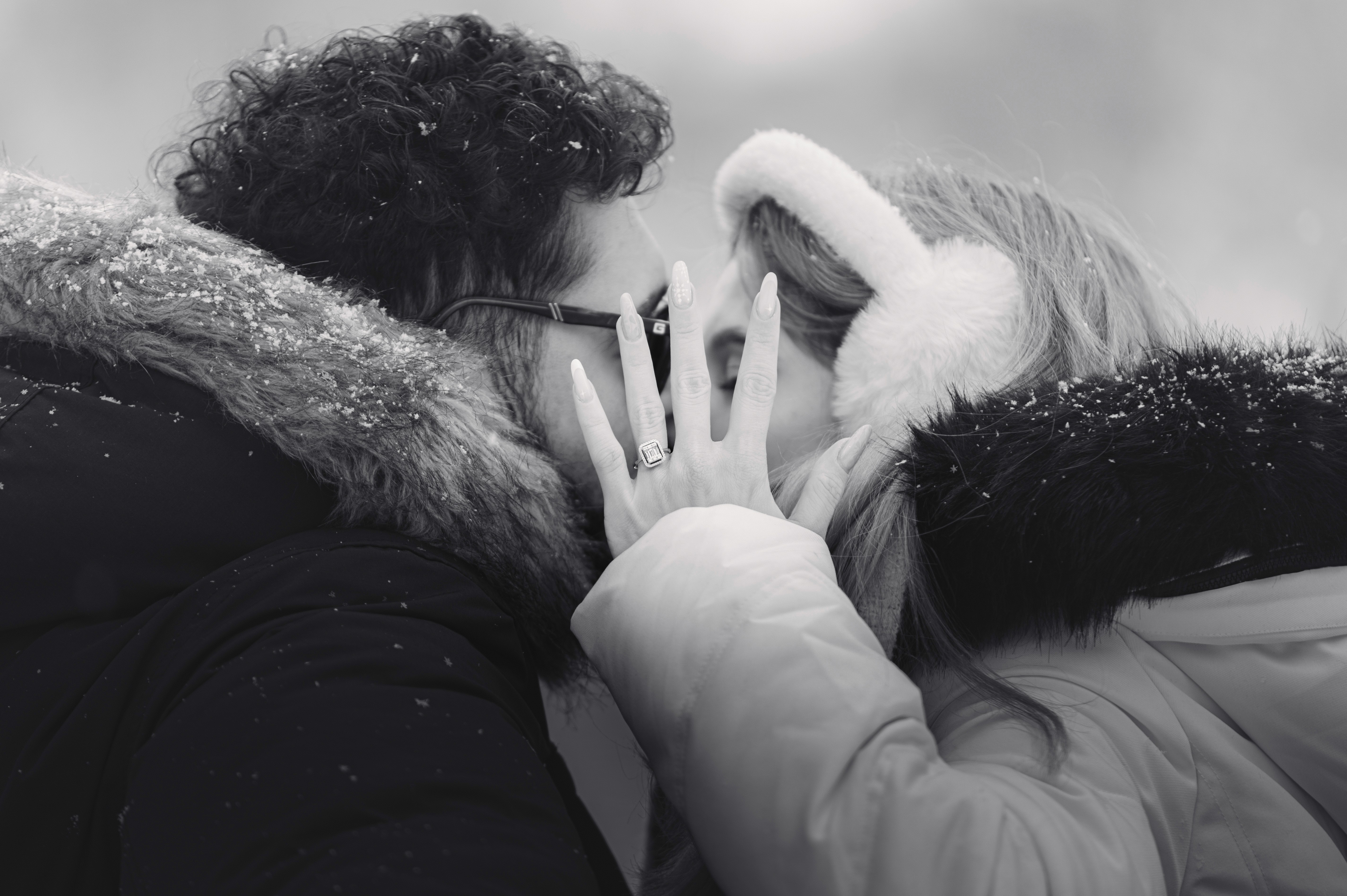 Ședință foto Save the Date de iarnă cu un cuplu îndrăgostit, surprins într-un moment intim, pe fundal de zăpadă