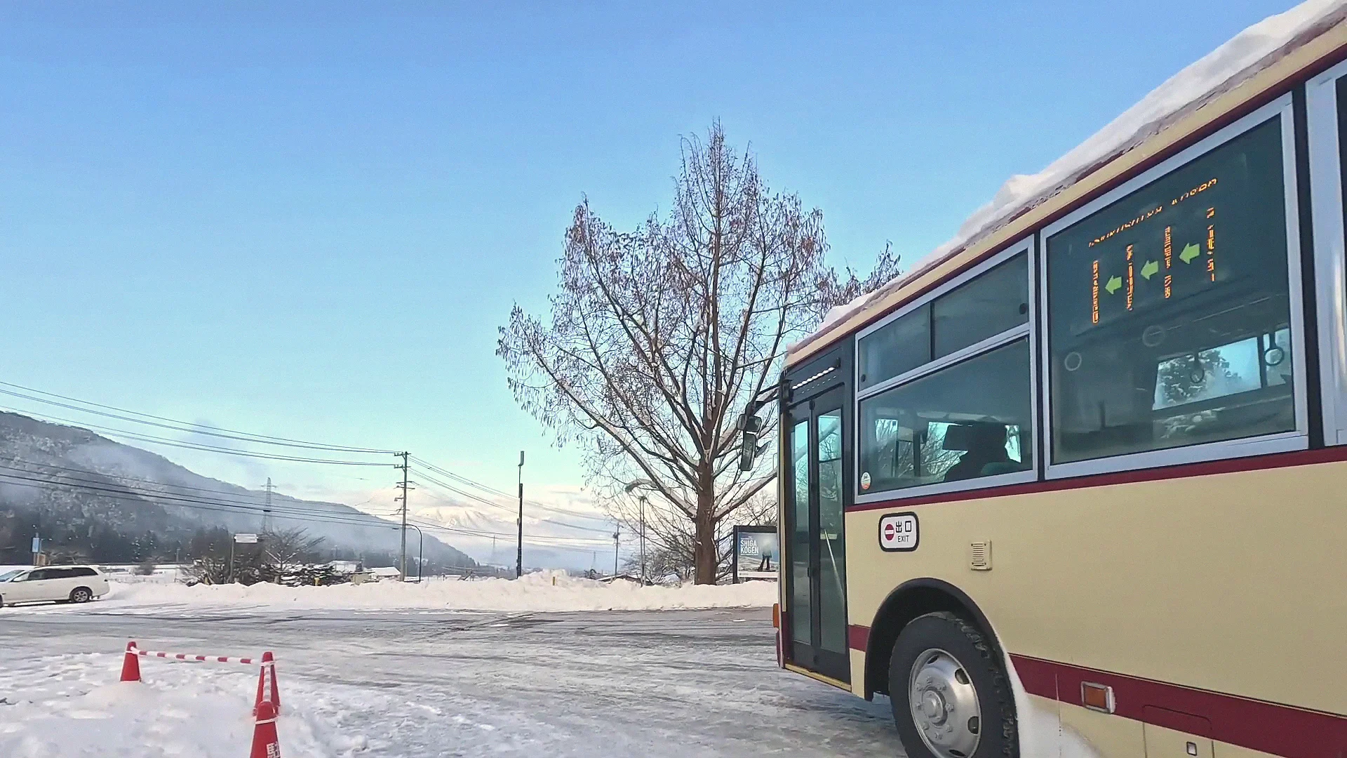 Bus to the snow monkey park waiting below snow-covered mountains