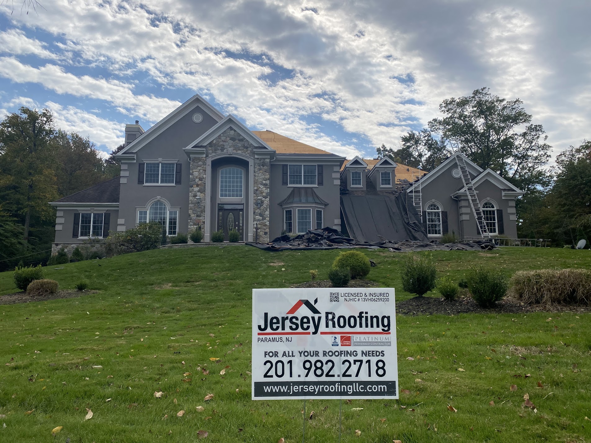A home with a Jersey Roofing LLC sign in the front yard in Garfield, NJ
