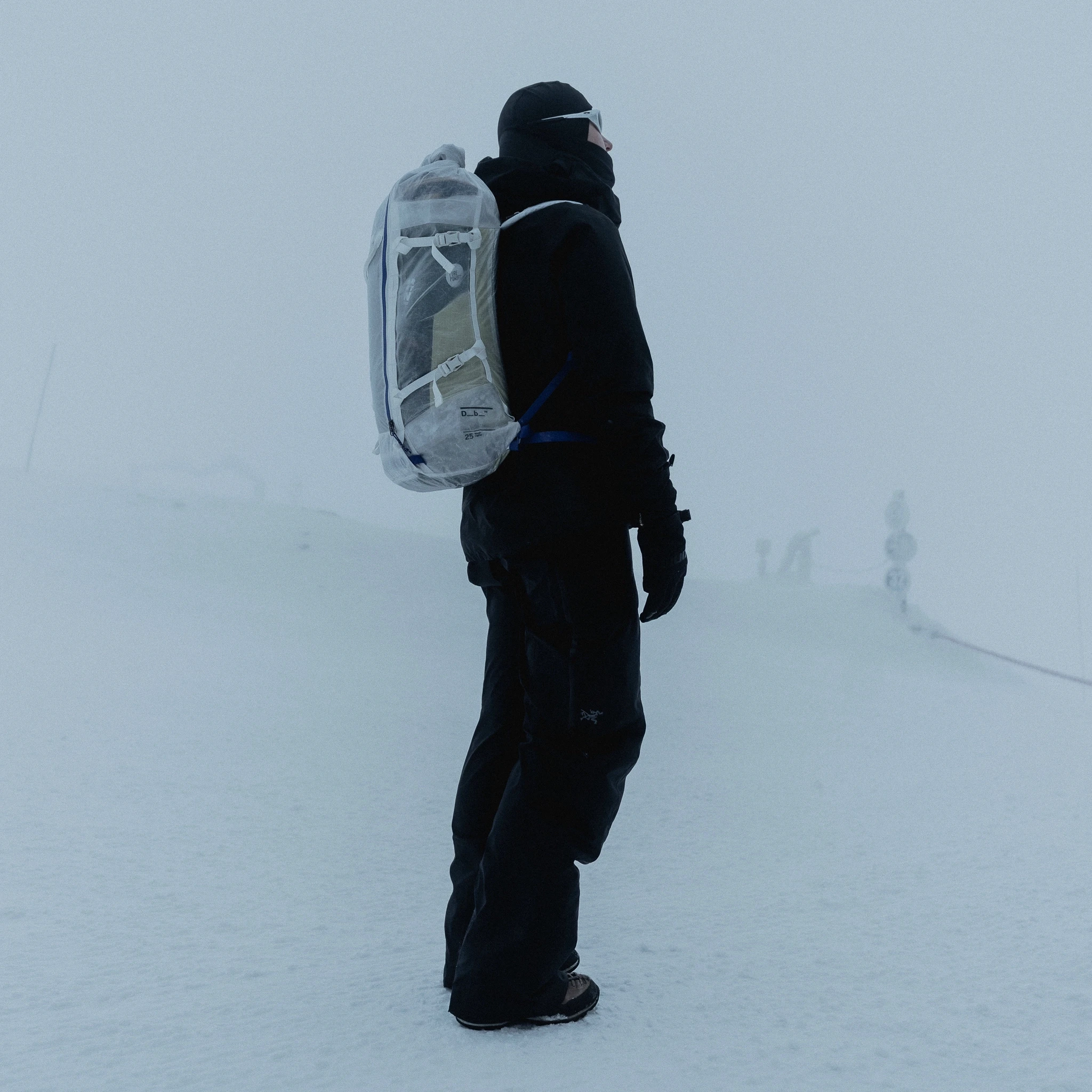 photo of a woman standing straight and wearing a backpack.
