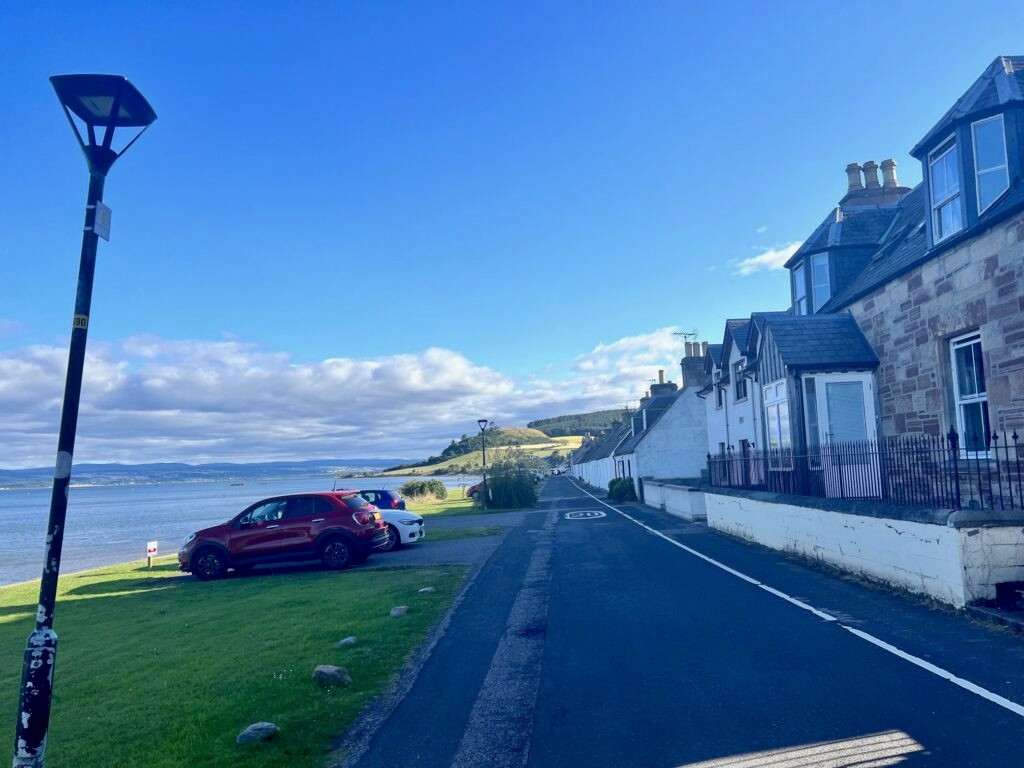 A road along the sea in Avoch, lined with houses.