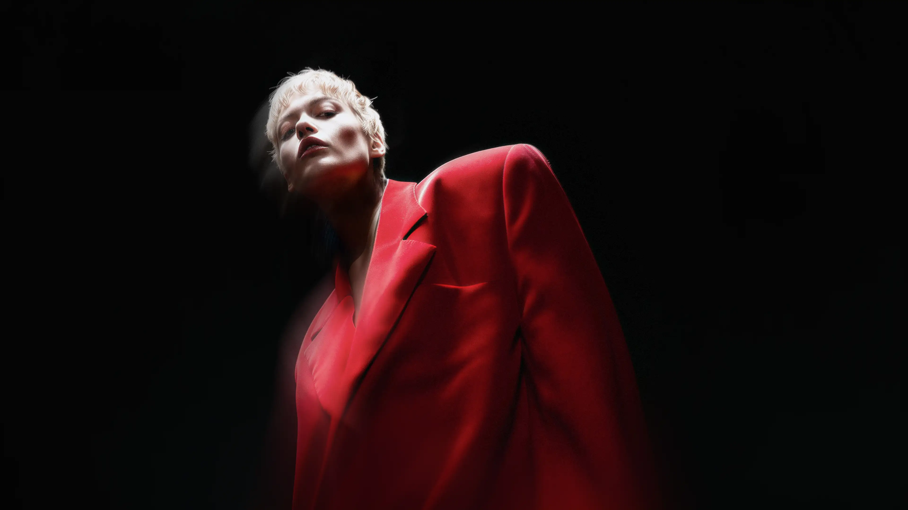 Cinematic hero image of a person wearing a vibrant red blazer against a dark background featuring the bold white Prodred wordmark.