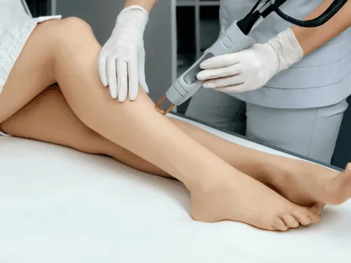 Professional performing laser hair removal on a client’s legs using advanced laser technology for long-lasting smooth skin.