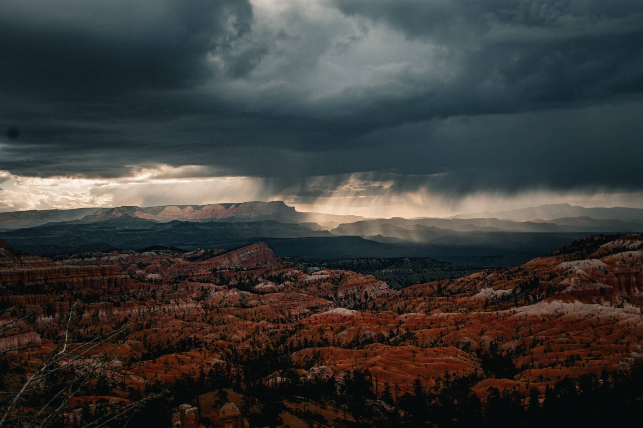 sunrise over red rocks with a stormy sky