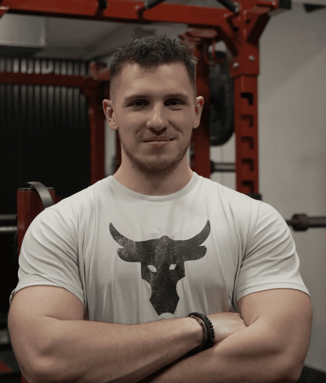 Adam, personal trainer, looking to the side confidently in a fitness studio