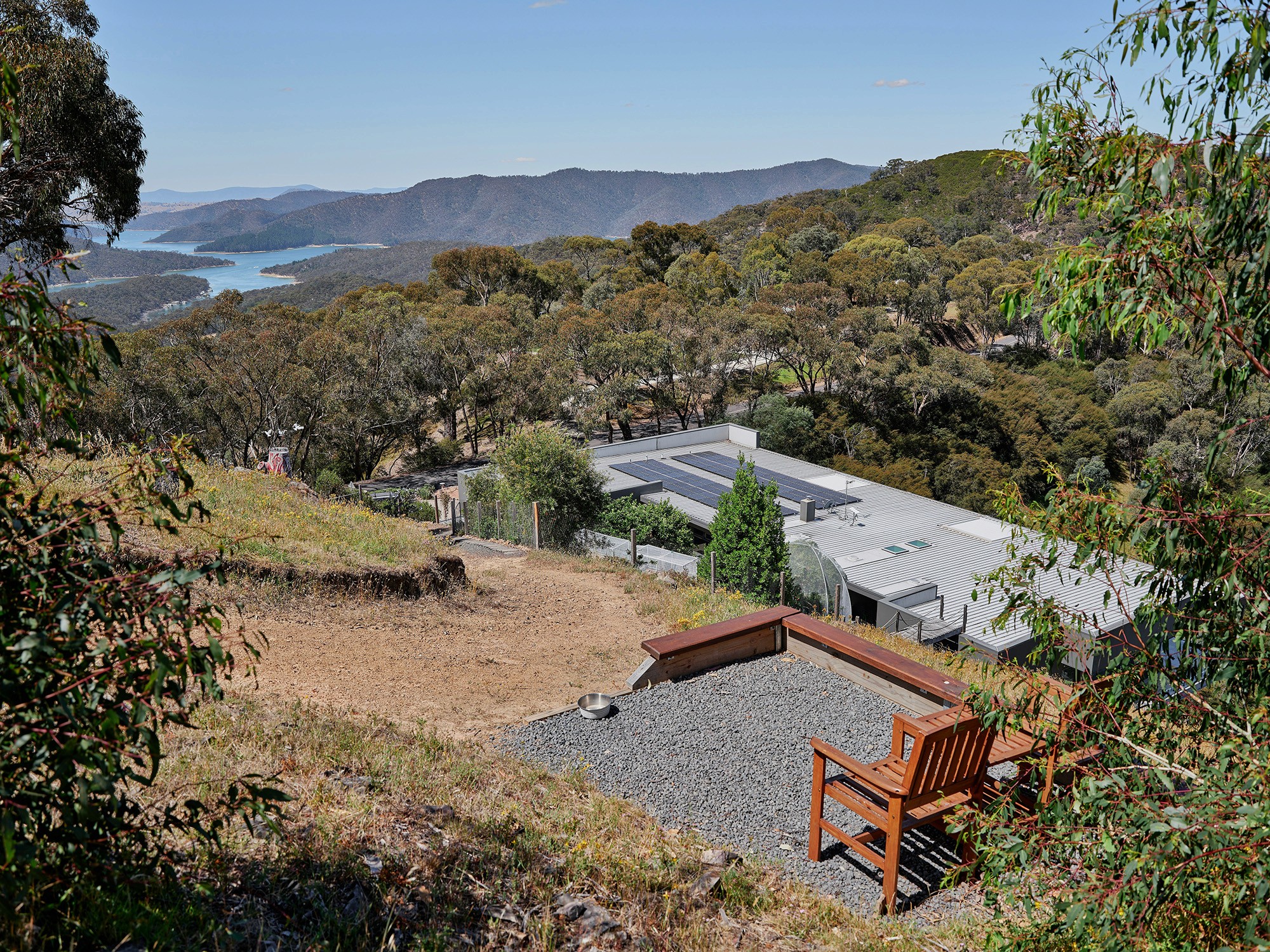 Wooden bench overlooking forested hills and a lake