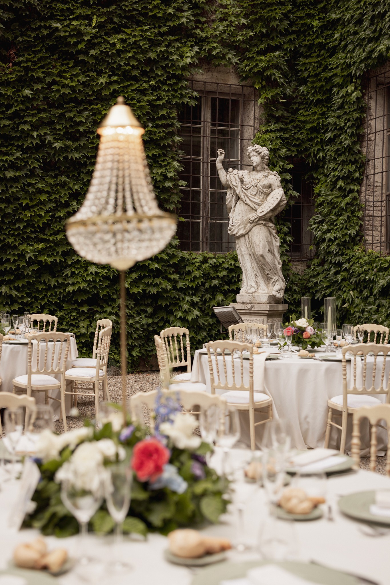 Tavolo di ricevimento alla Rocca di Soragna con centrotavola floreale e lampada vintage, matrimonio Eleonora e Bernardo
