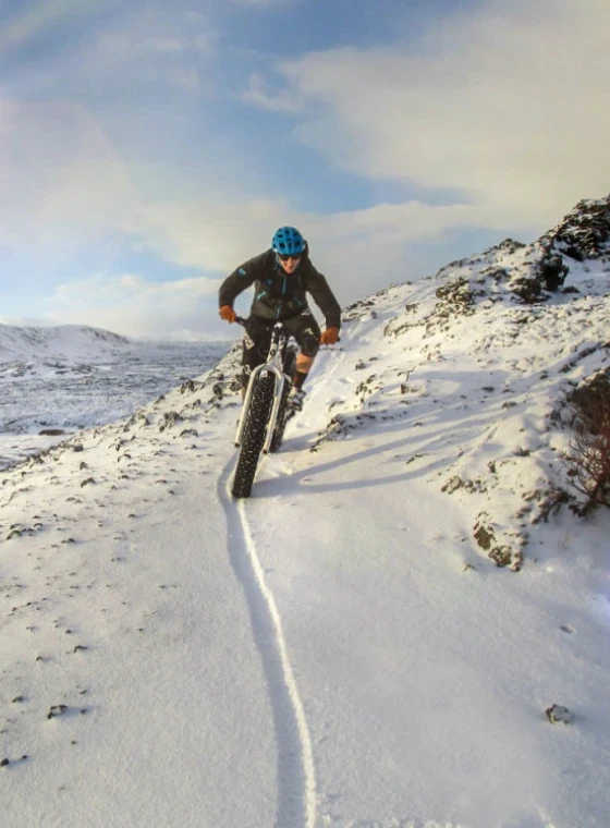 A female rides her fatbike towards camera