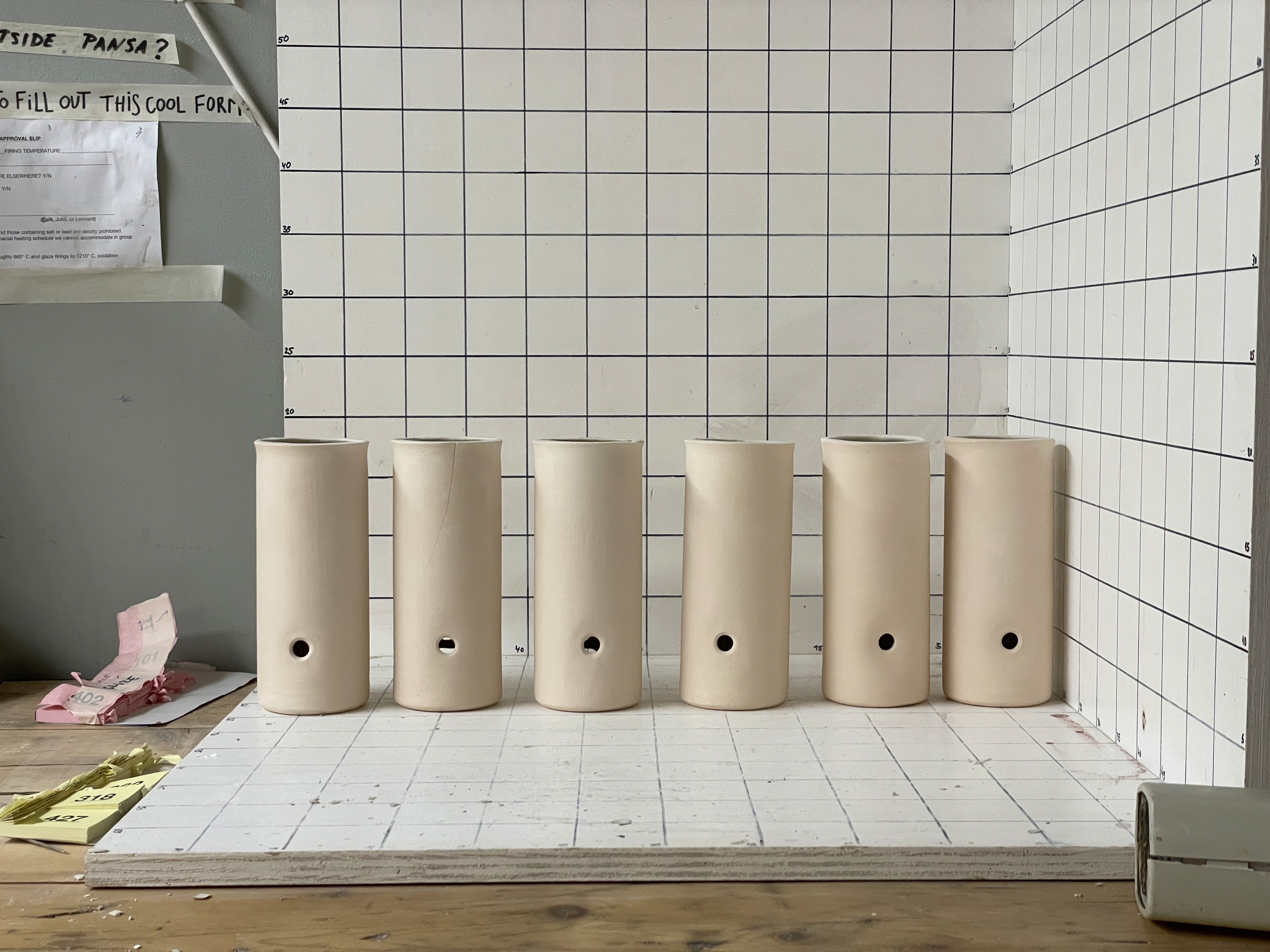 Image of ceramic speaker prototypes in front of a grid