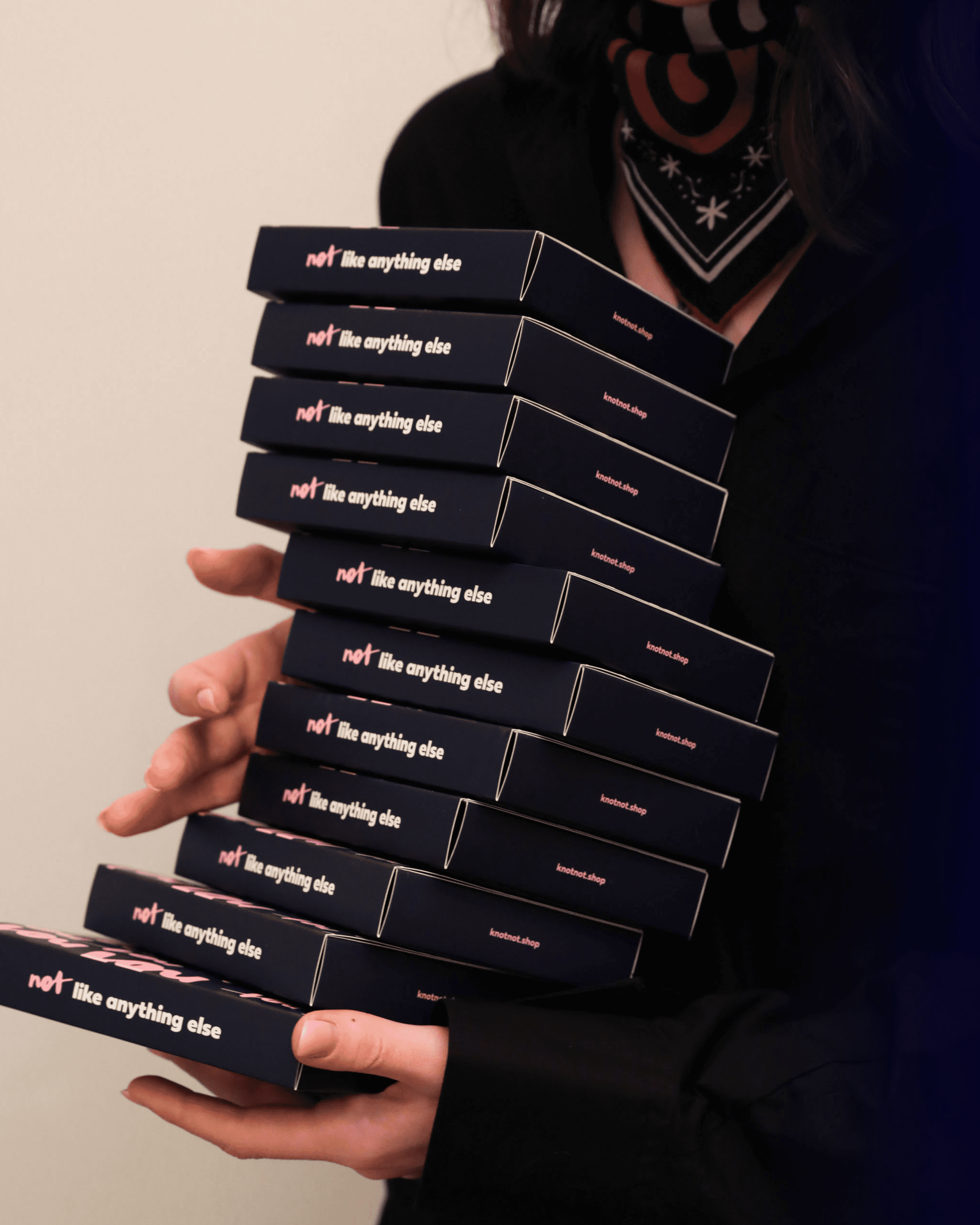 Knot/Not product boxes held in a stack