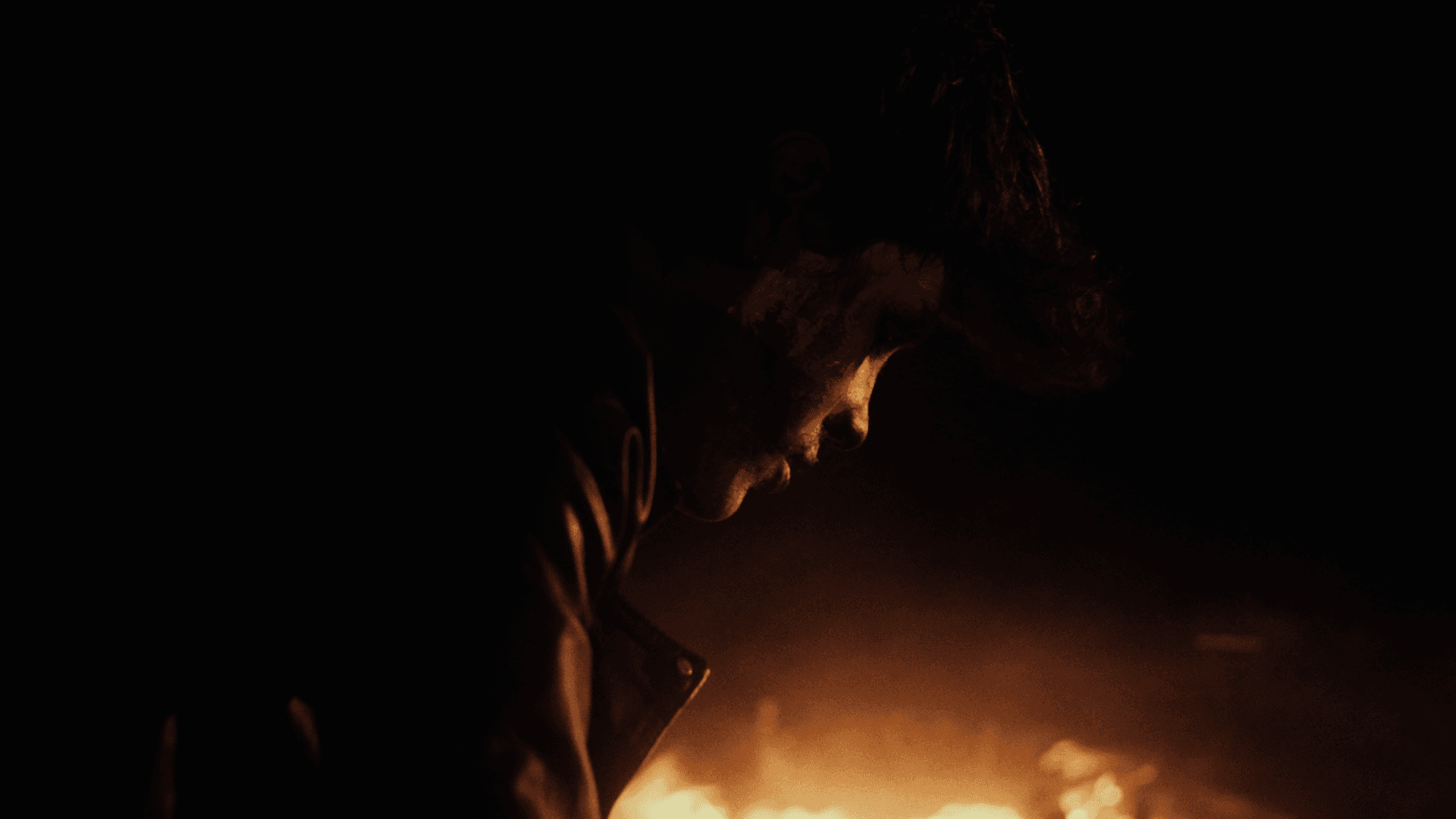 View of the French countryside through a stone villa’s open living room, with sofas and trees framing the scene