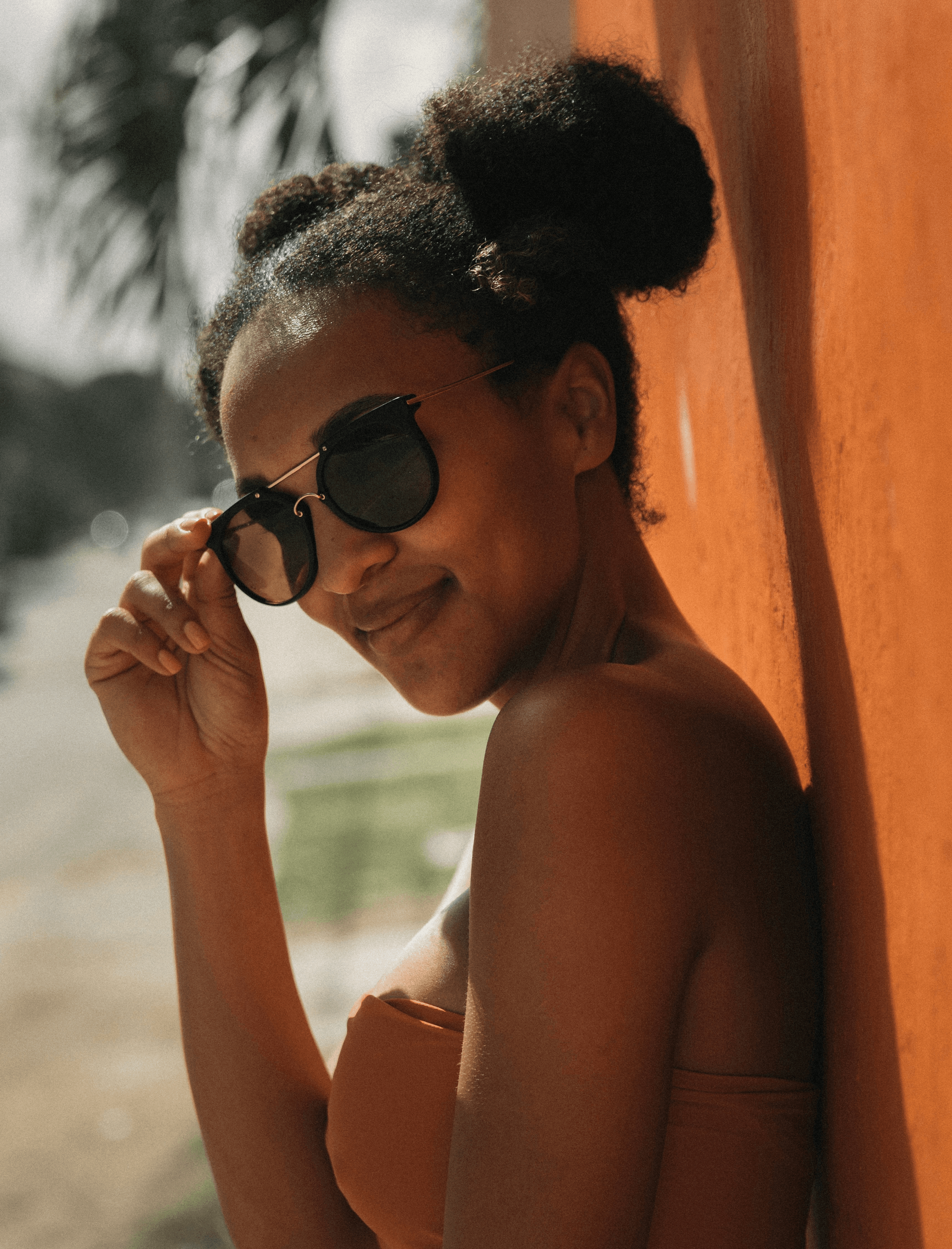 woman in brown bra leaning on wall