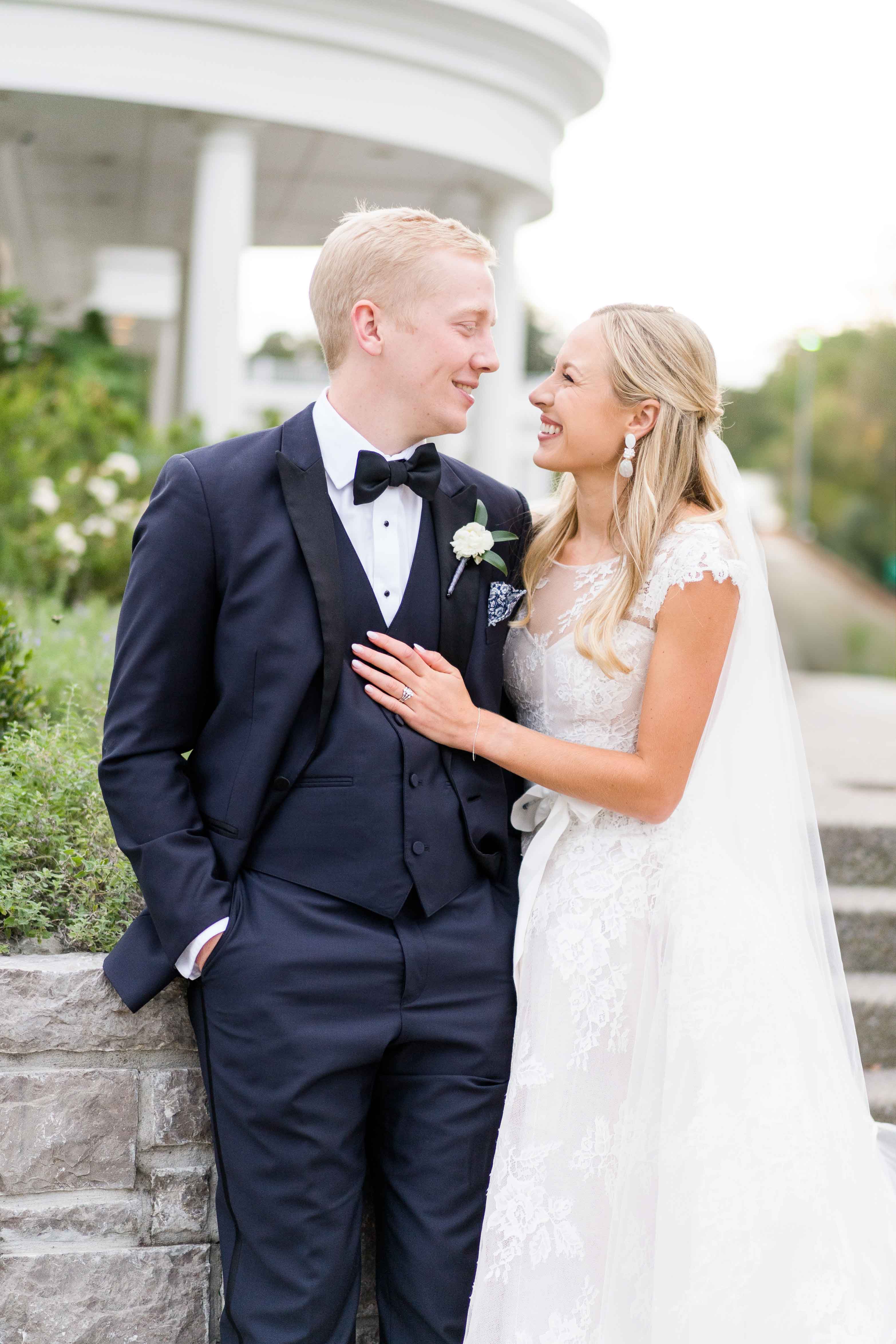 Bride and groom looking at each other on their wedding day outside.