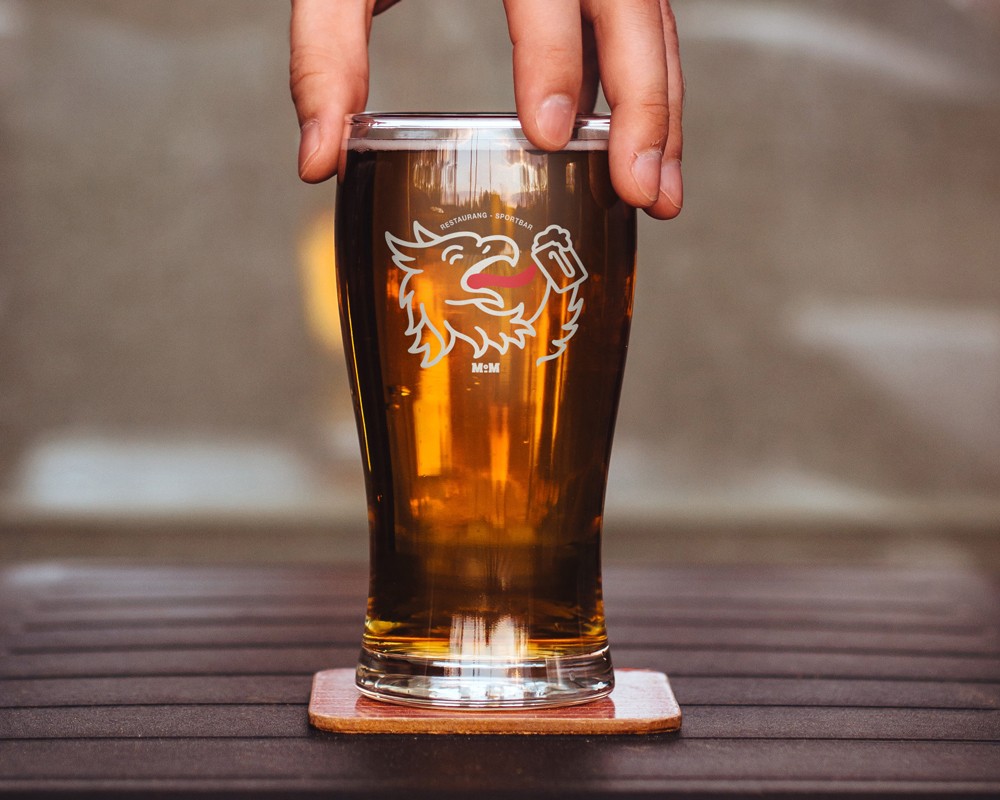 A glass of amber craft beer on a dark surface, part of the visual identity shoot for Mat & Malt.
