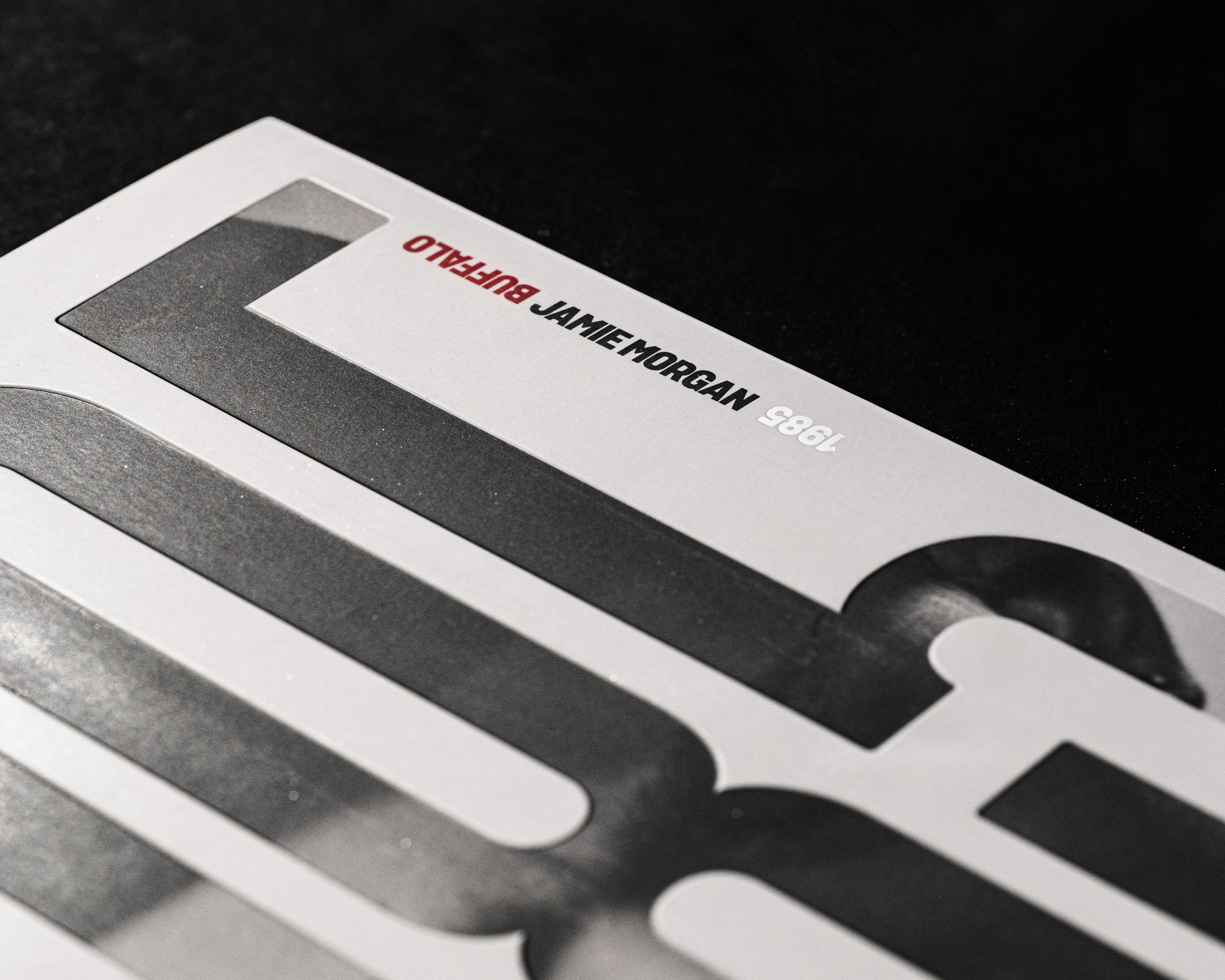 Close-up of a magazine cover featuring bold, graphic text and a minimalist design on a dark background.