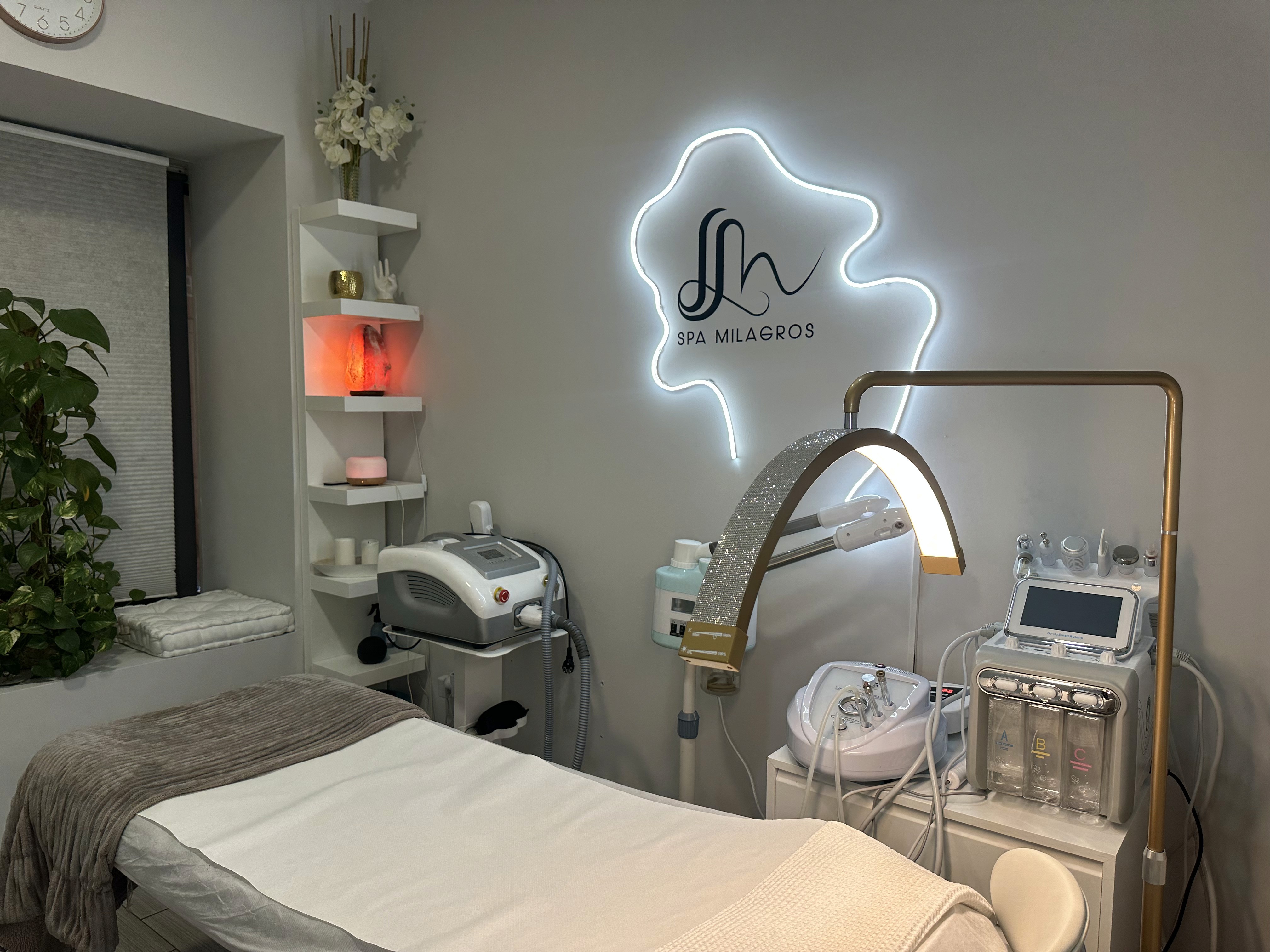 A luxurious indoor spa area with a pool, lounge beds, and a breathtaking view of a city skyline at sunset. The golden lighting enhances the warm and tranquil atmosphere, creating a perfect relaxation retreat.
