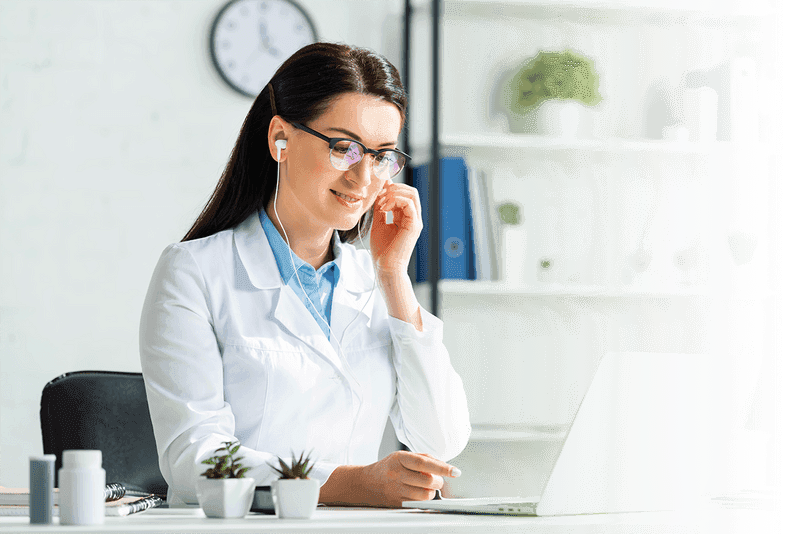 A doctor speaks at a laptop