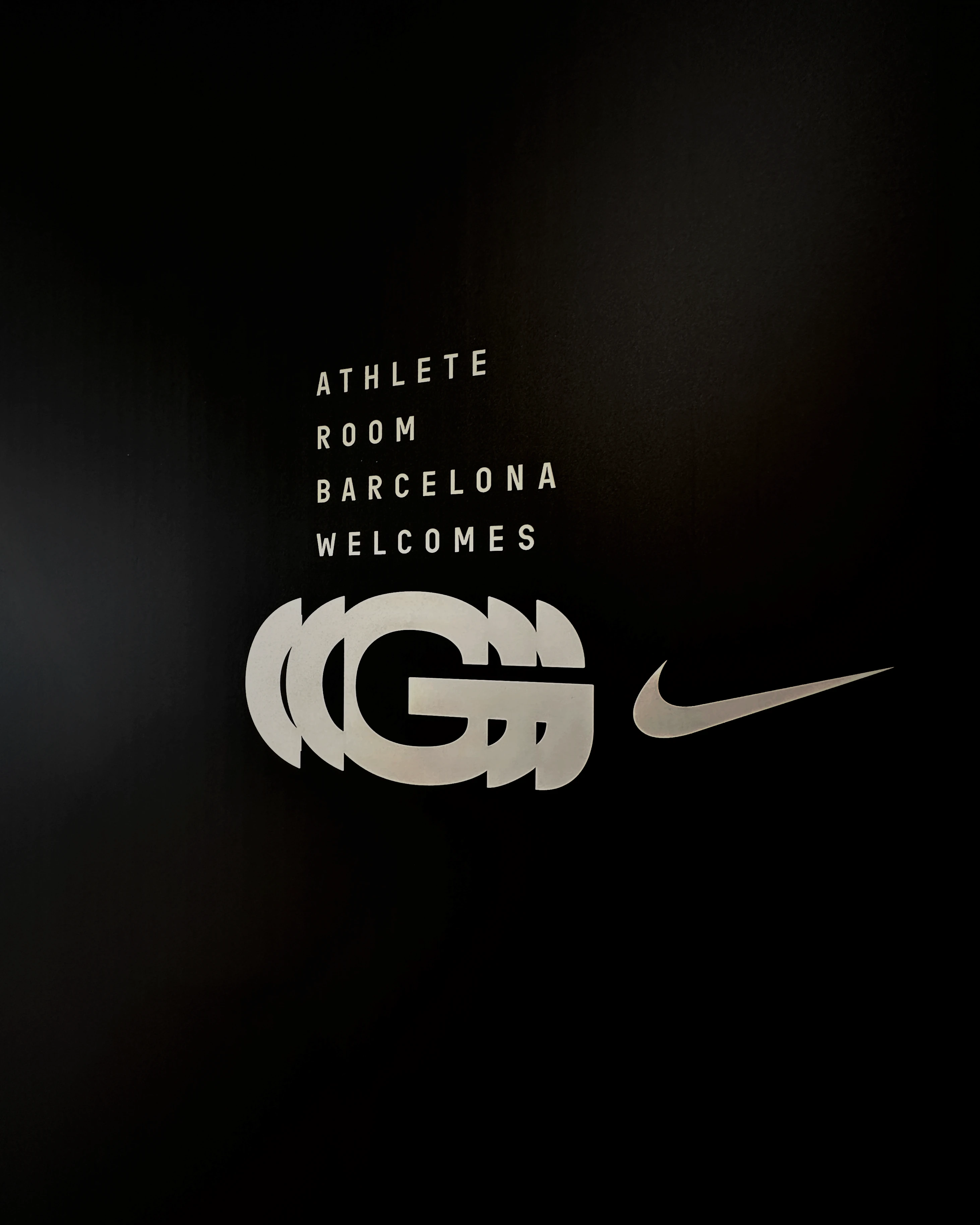 Barcelona Nike Athlete Room welcome signage with the double G monogram and the Nike swoosh, campaign design by Sebastian Saavedra