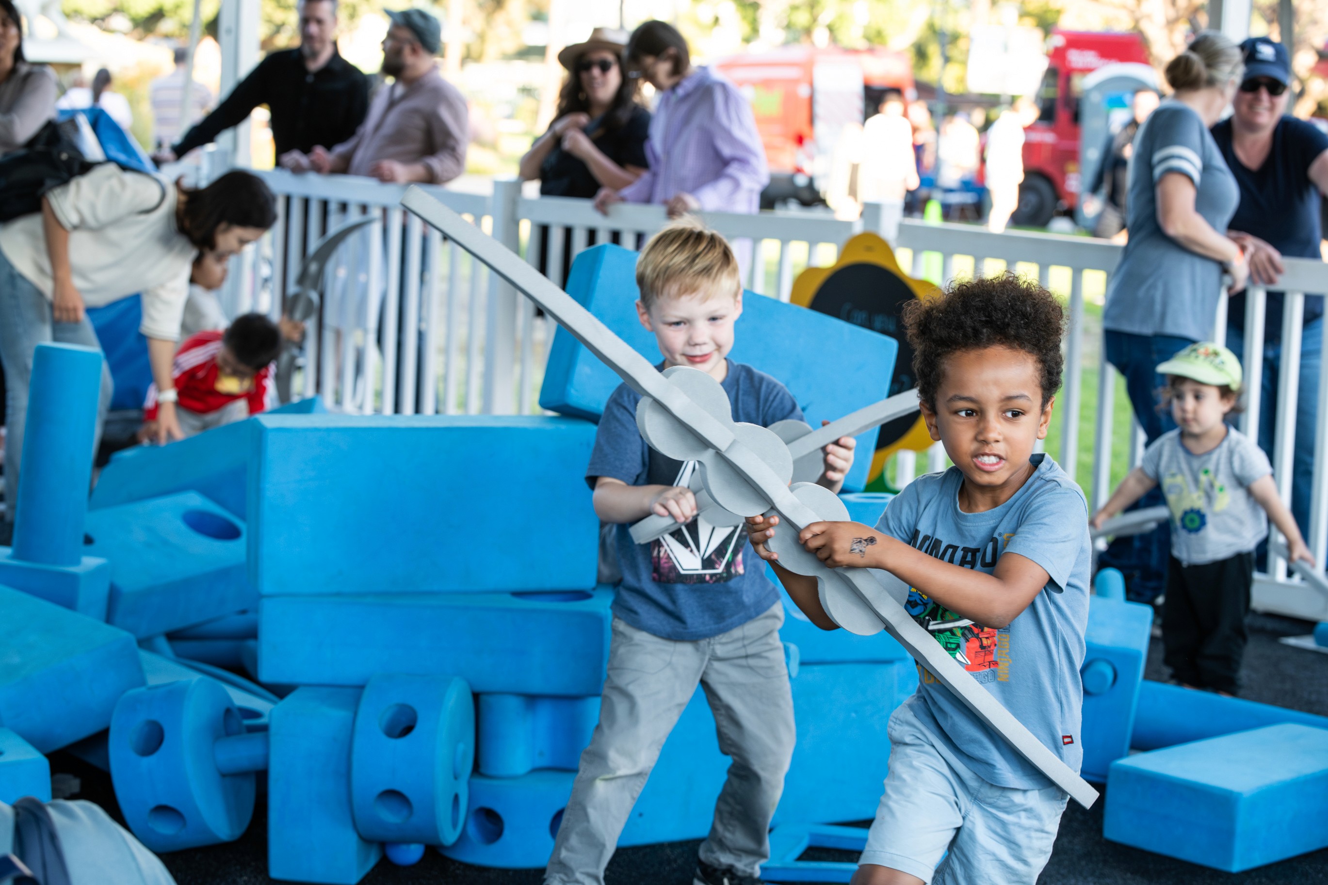 Event volunteers helping manage a booth full of kids participating in creative crafts.