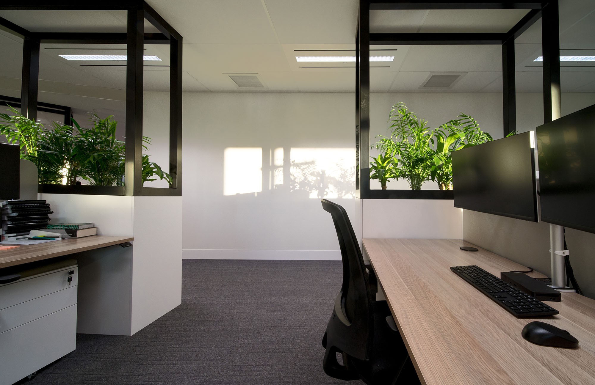 A clean and modern office interior with computers, showcasing a productive hot desking environment by myOffice