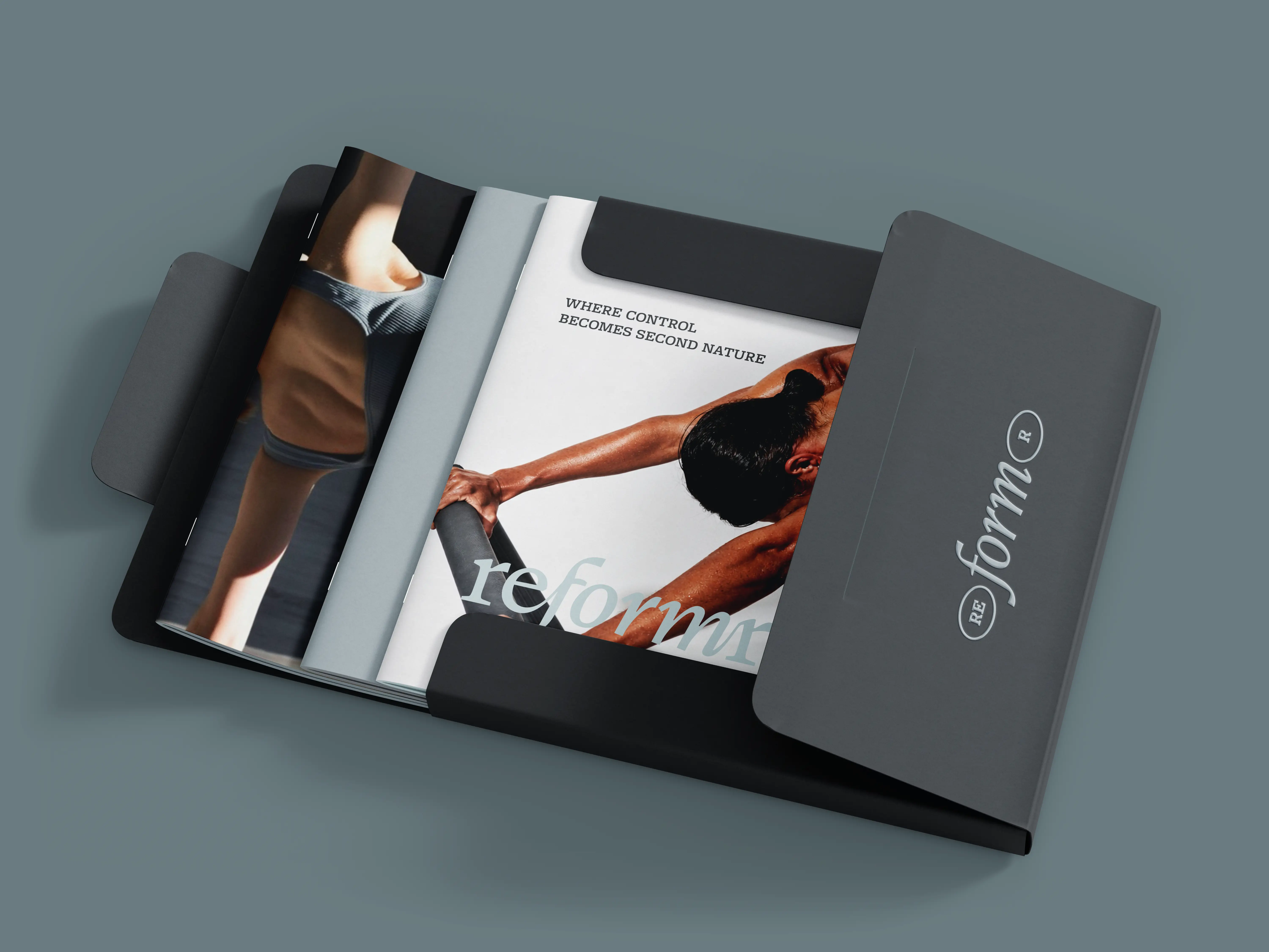 Reformr Pilates Studio brand identity — open  folder with embossed logo on cover and 3 brand booklets inside