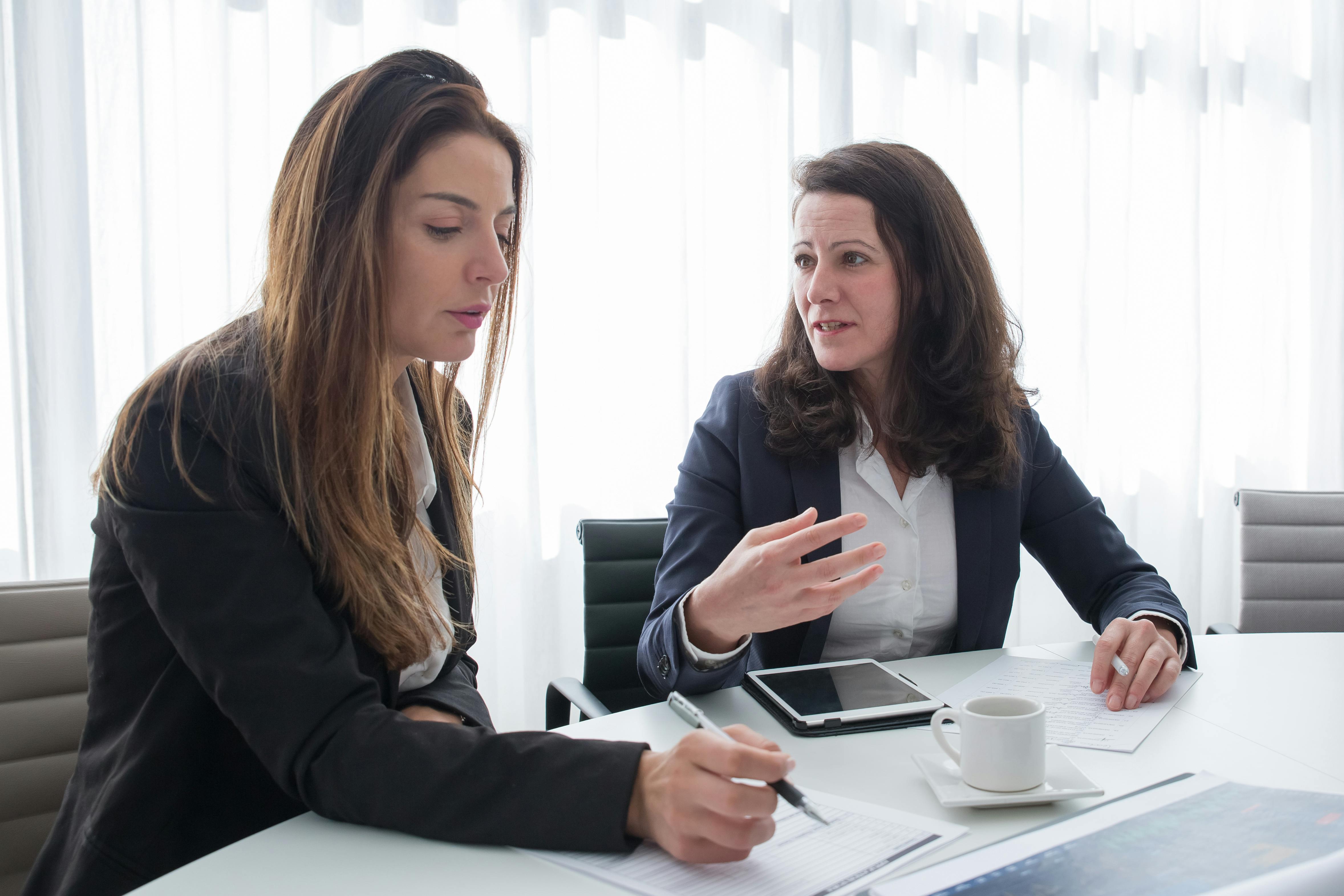 Businesswomen performing a company internal audit to ensure their systems meet ISO standard requirements.