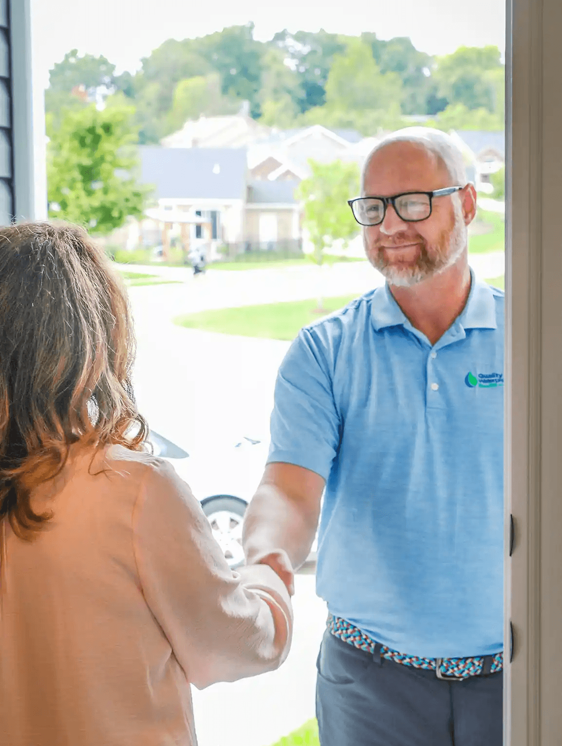 Photo of a home owner greeting a waterproofing inspector at the door