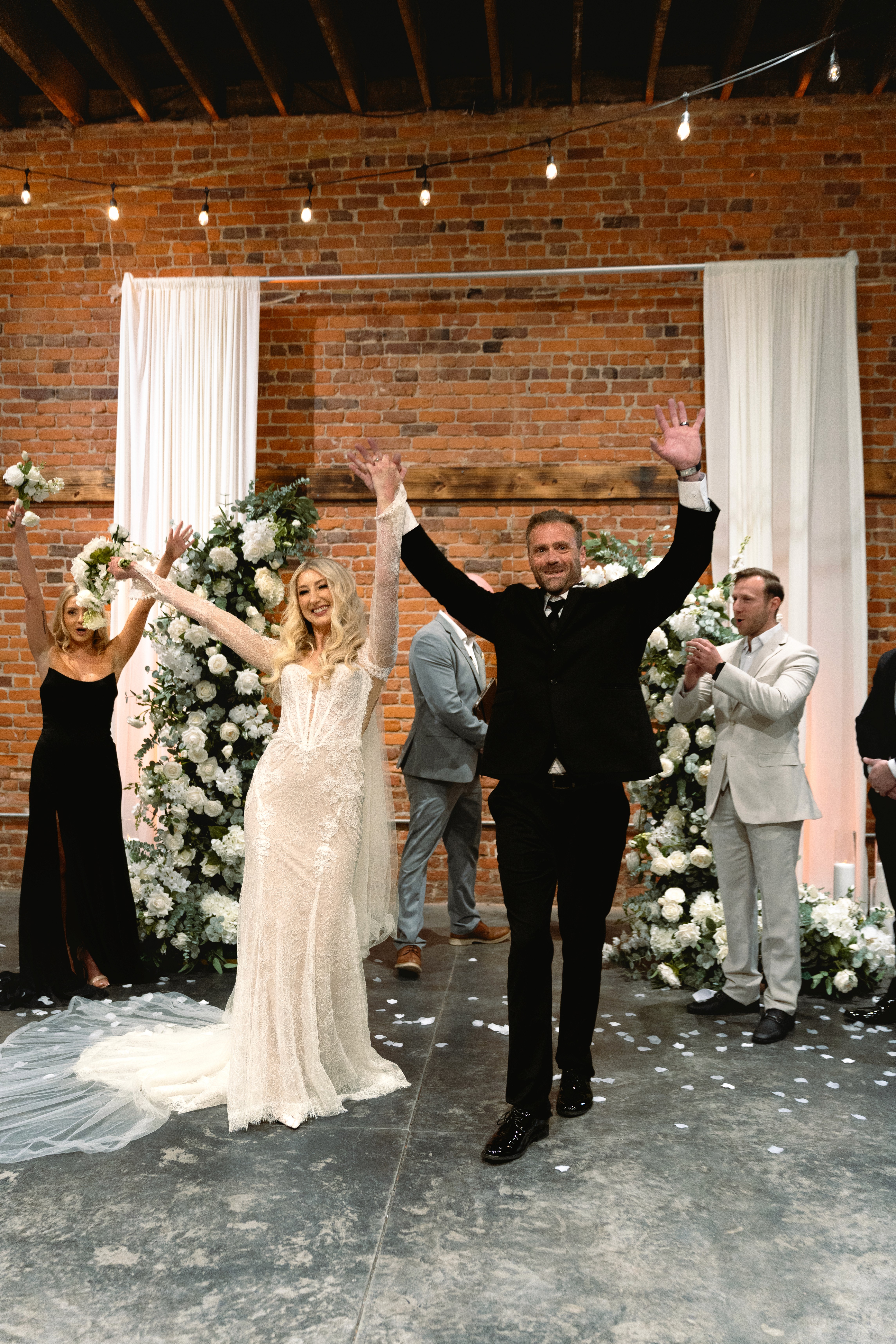 A bride in a lace wedding dress gently holds.