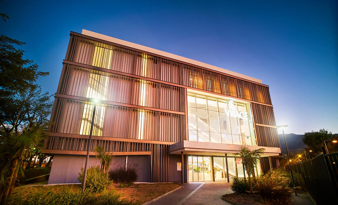 hotographie d'architecture au crépuscule : bâtiment moderne Le Village by CA à La Réunion — Valorisation de patrimoine immobilier et tertiaire par David Dijoux