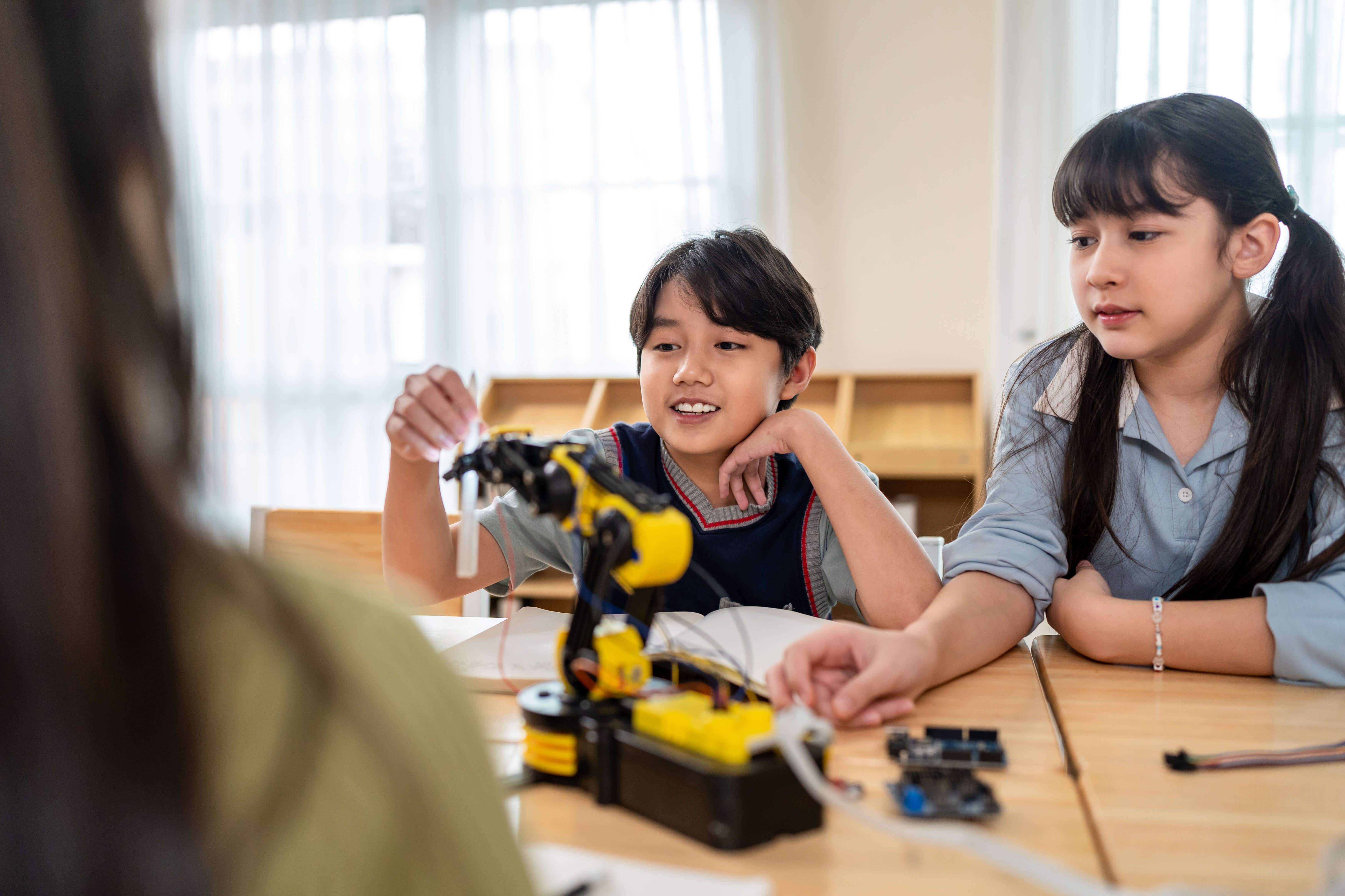 A teacher is showing a globe to a group of students, pointing to different locations as the students watch attentively